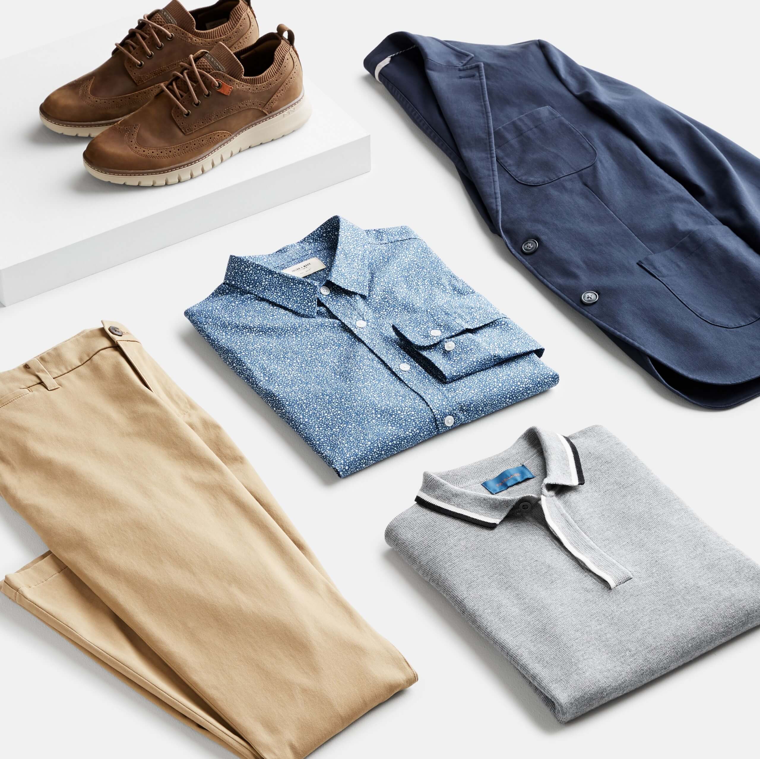 Stitch Fix Men’s outfit laydown featuring khaki pants, grey polo, chambray button-up, navy blazer and brown oxford shoes.