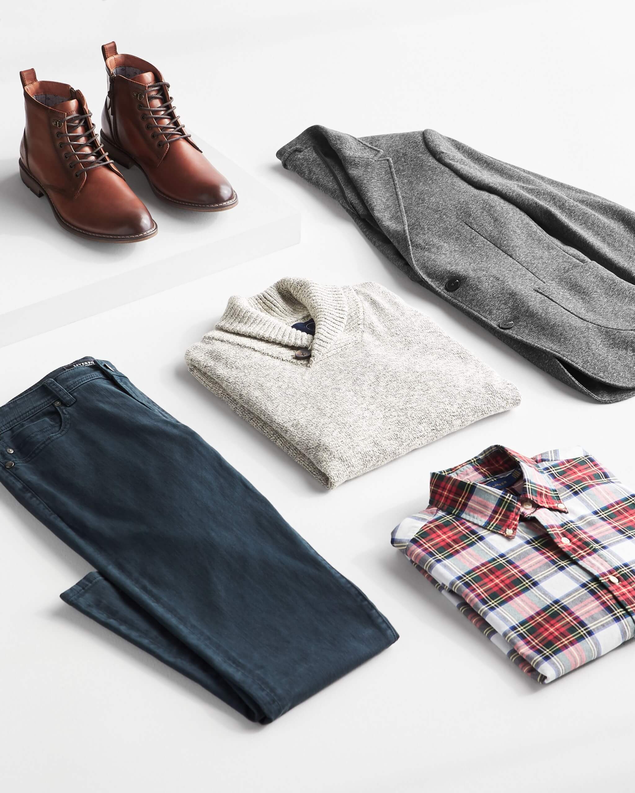 Stitch Fix men’s outfit laydown featuring red plaid button-down shirt, grey pullover shawl, grey blazer, dark wash jeans and brown leather boots. 