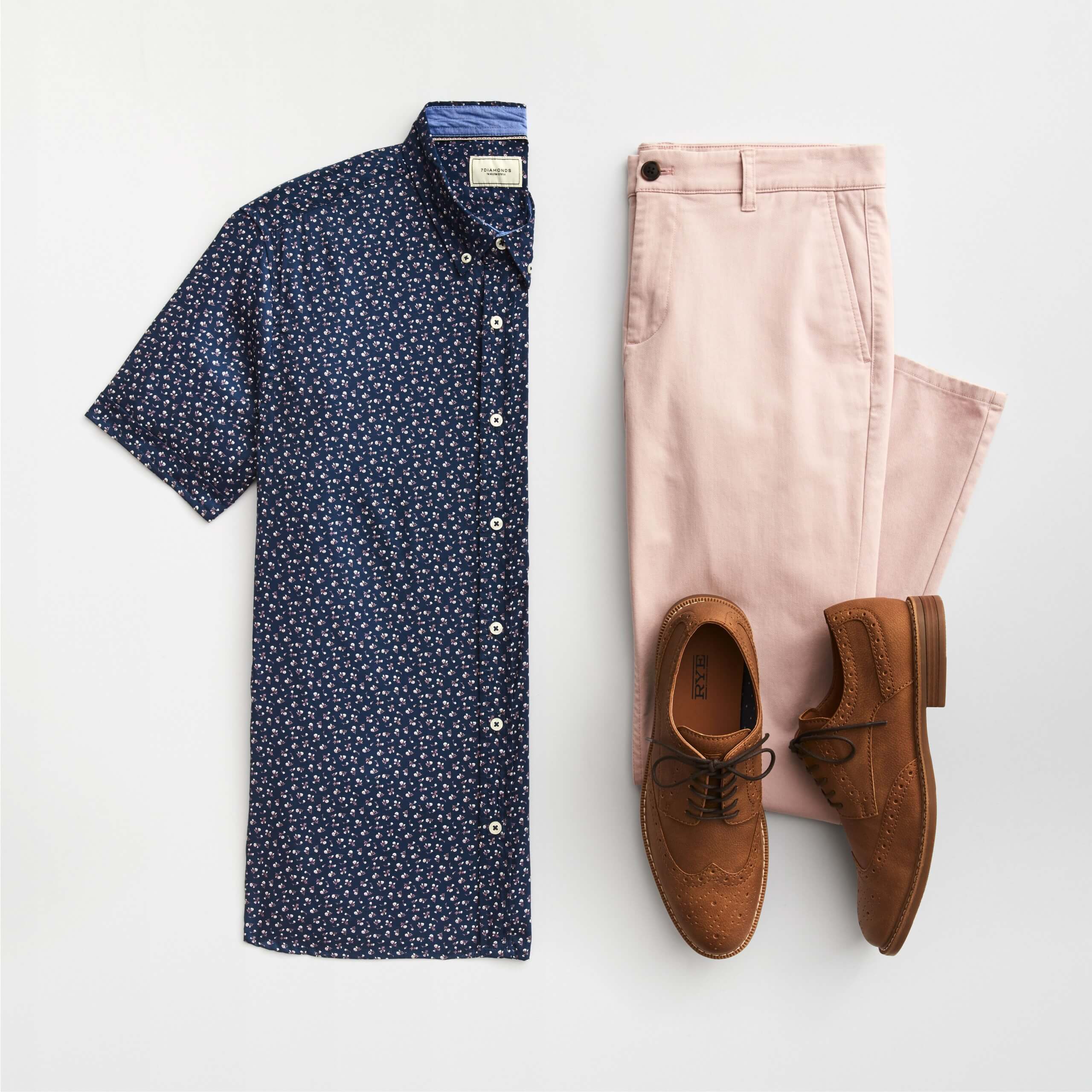 Stitch Fix Men’s outfit laydown featuring short-sleeved navy button-down with small floral print, pink chinos and brown brogues. 