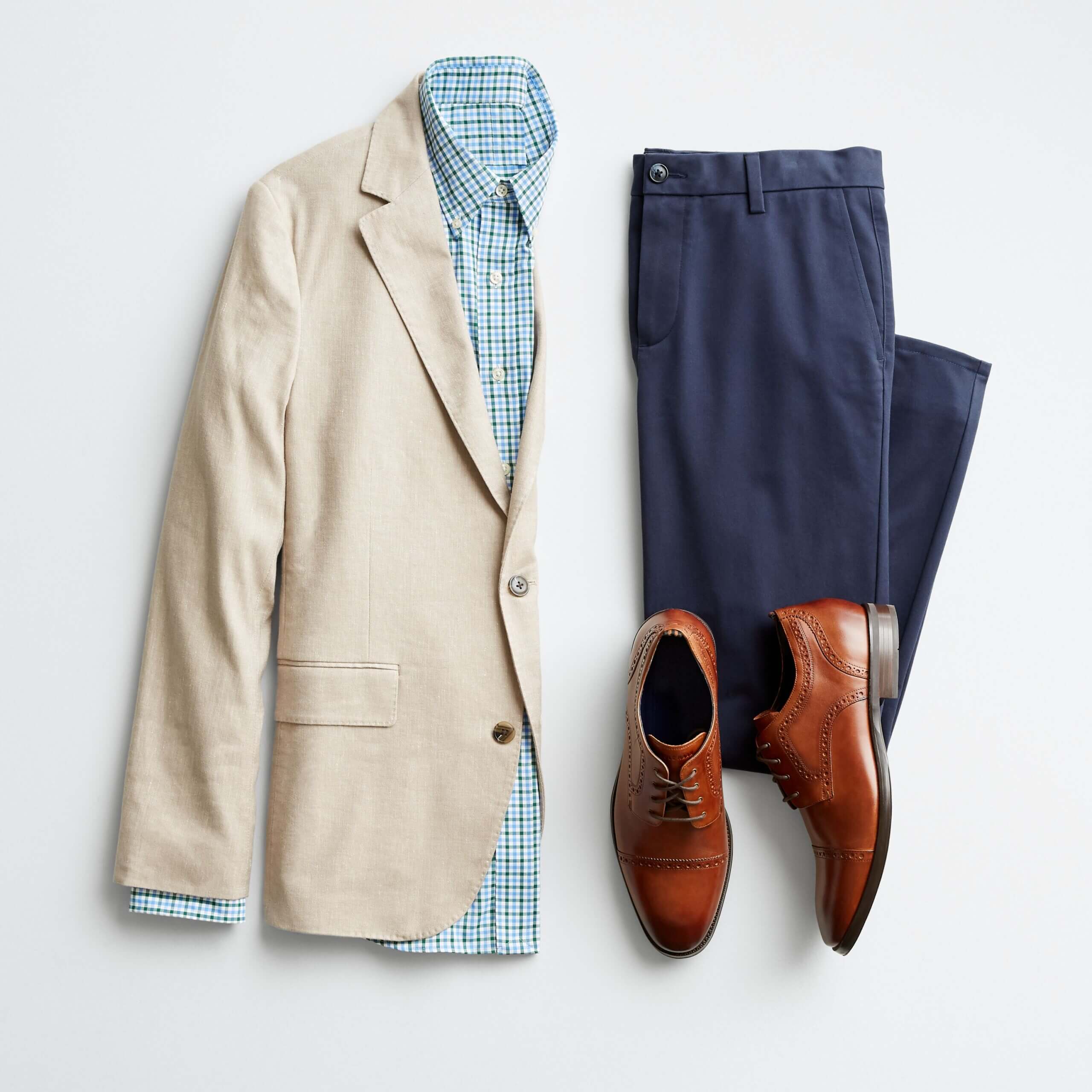 Stitch Fix men's outfit laydown featuring navy trousers, blue button-up, khaki blazer and cognac shoes.