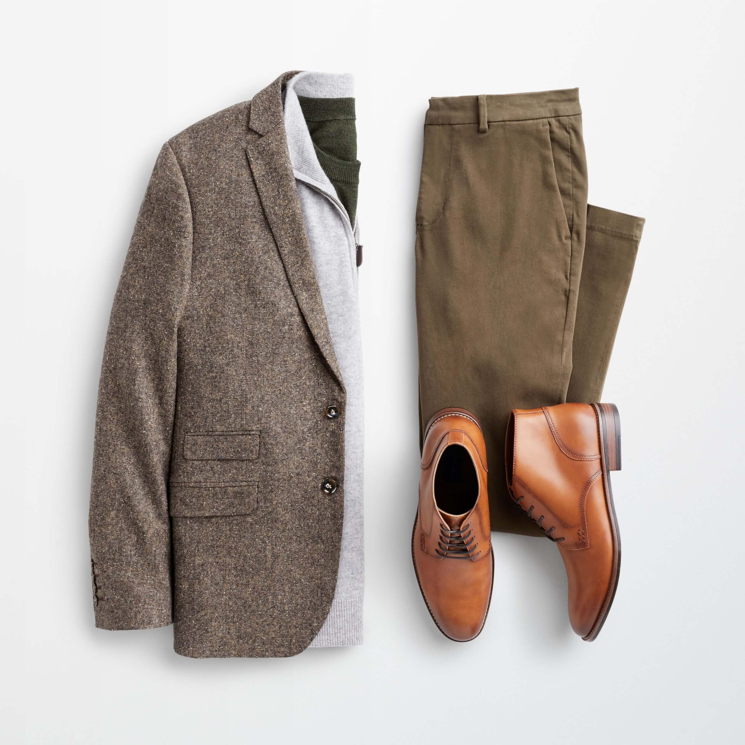 Stitch Fix Men's outfit laydown featuring brown blazer over grey quarter-zip wool sweater, next to olive-green trousers and brown leather chukkas. 