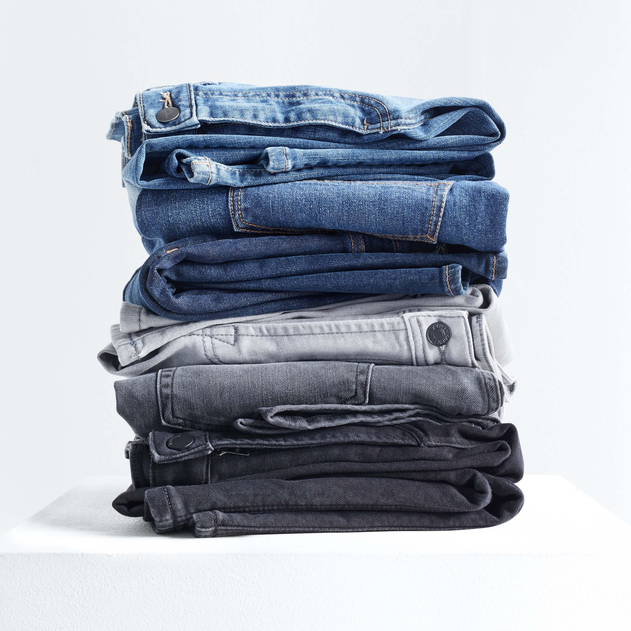 Stitch Fix Men's stack of jeans in light blue, dark blue, grey and black.