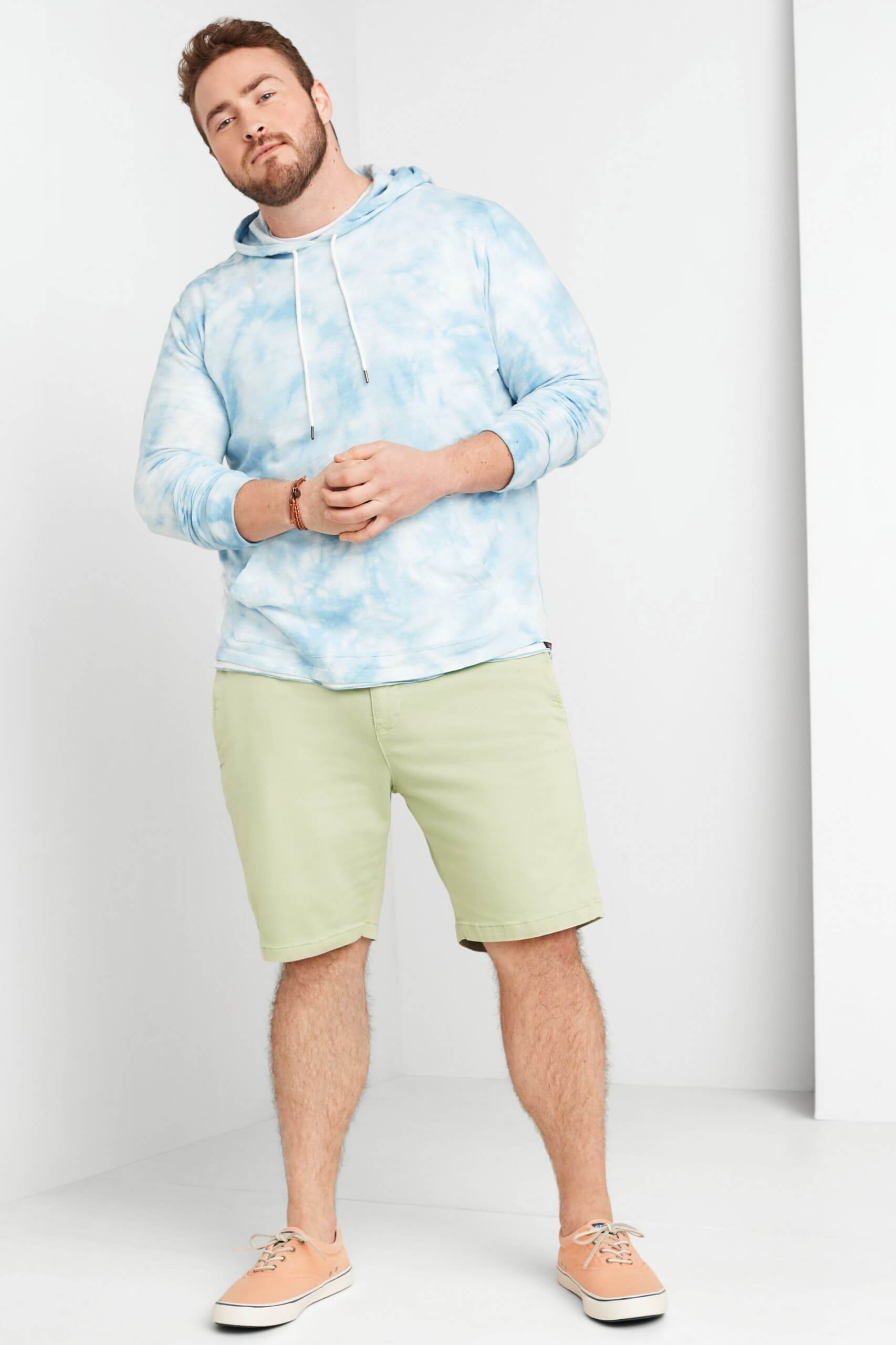 Stitch Fix Men's model wearing baby blue tie-dye hoodie, green shorts and white sneakers.