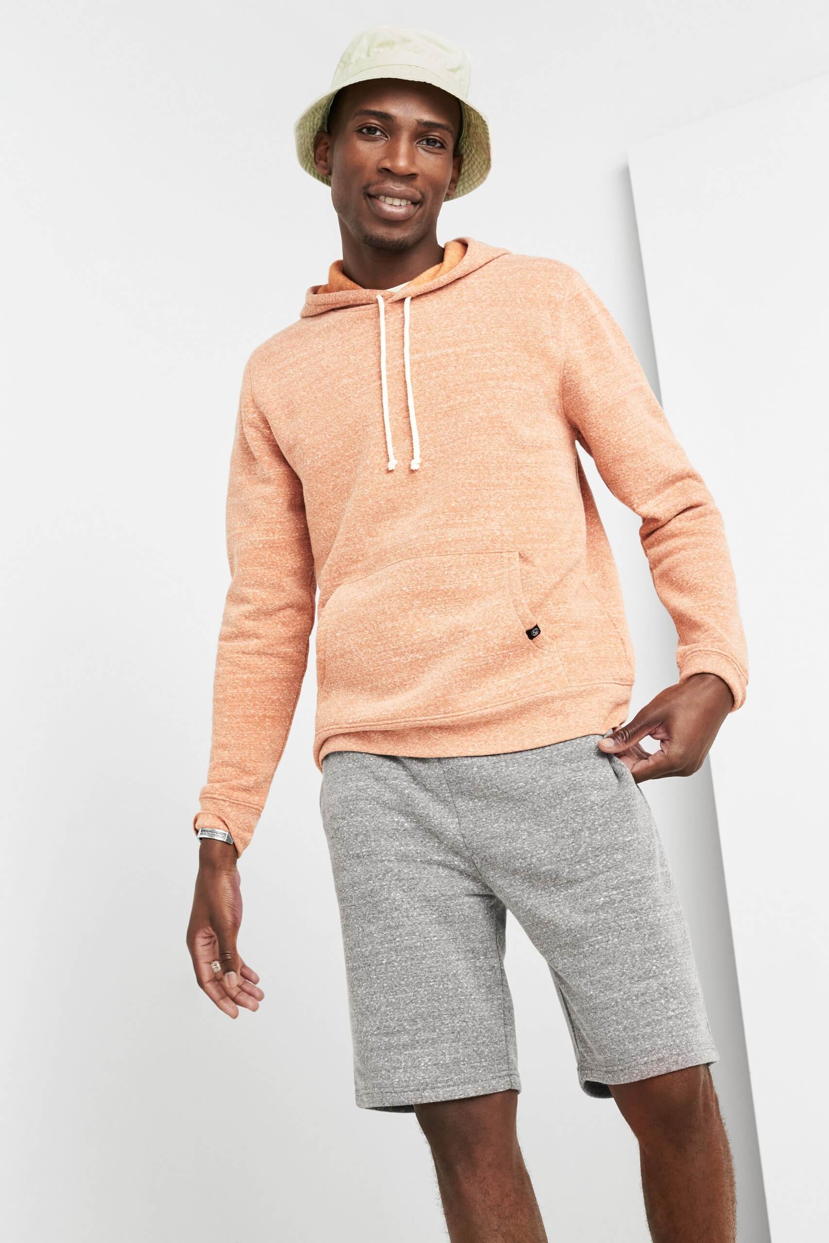 Stitch Fix Men's model wearing peach hoodie and grey shorts. 