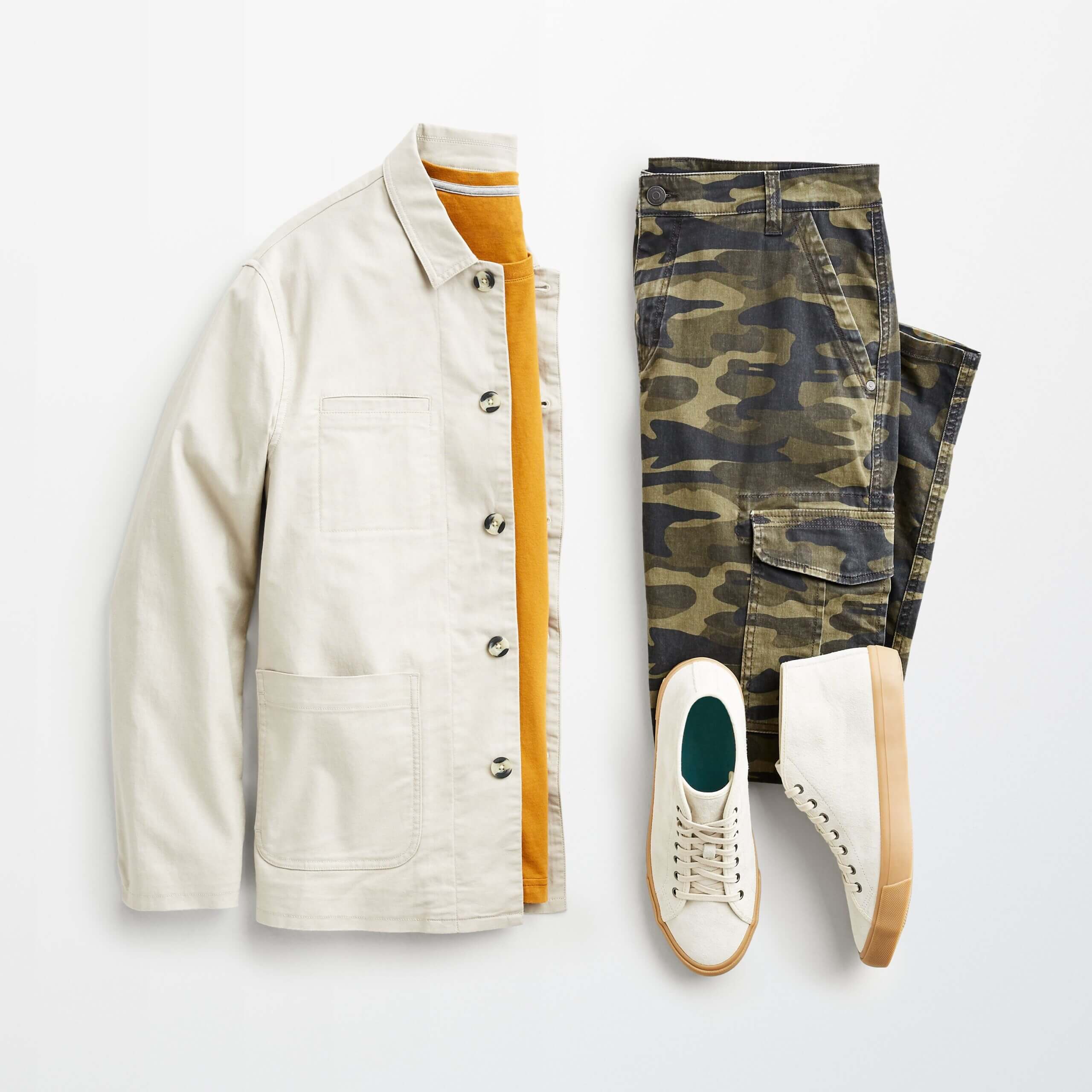 Stitch Fix men's outfit laydown featuring chore coat over mustard tee next to cargo pants and suede sneakers.