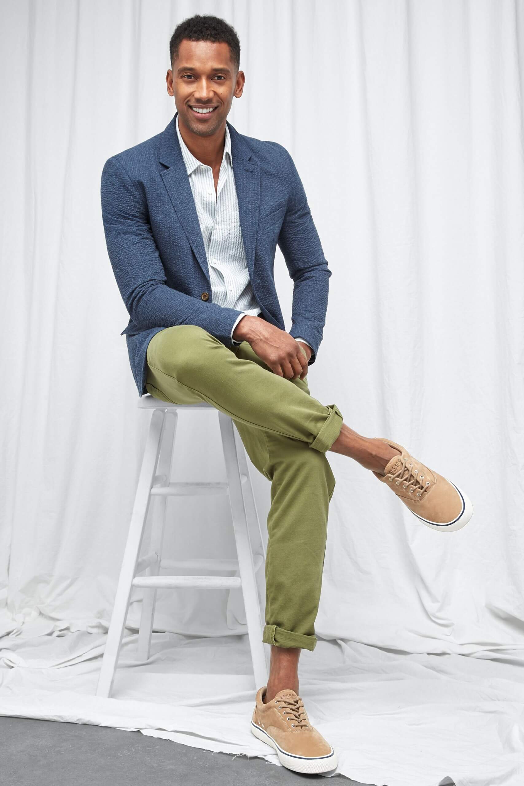 Stitch Fix men's spring wedding guest attire on model wearing green pants, white button-down shirt, blue blazer and tan shoes.