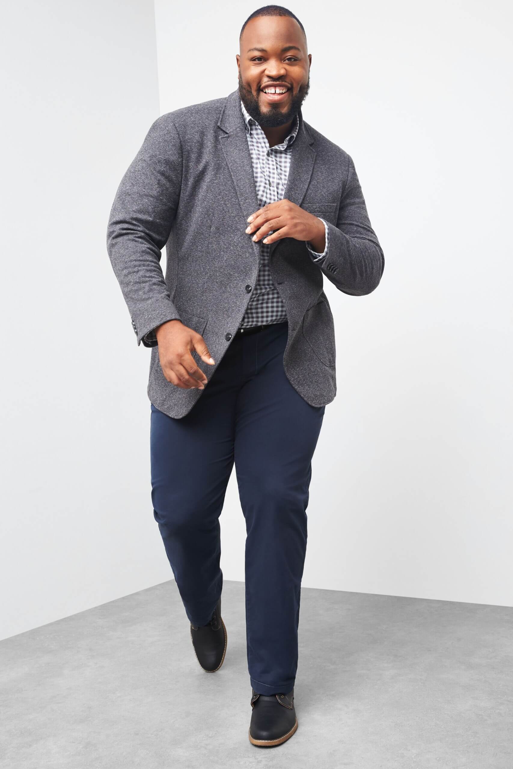 Stitch Fix men's model wearing graduation outfit featuring a grey sport coat, blue-patterned button-down, navy blue pants and black shoes.
