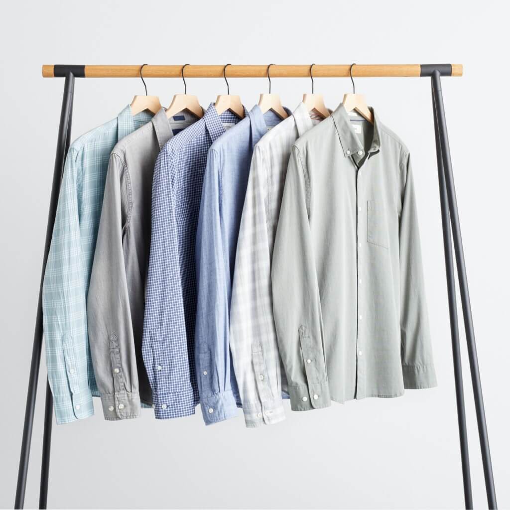 Stitch Fix men's collection of various button-down shirts hanging on rack.