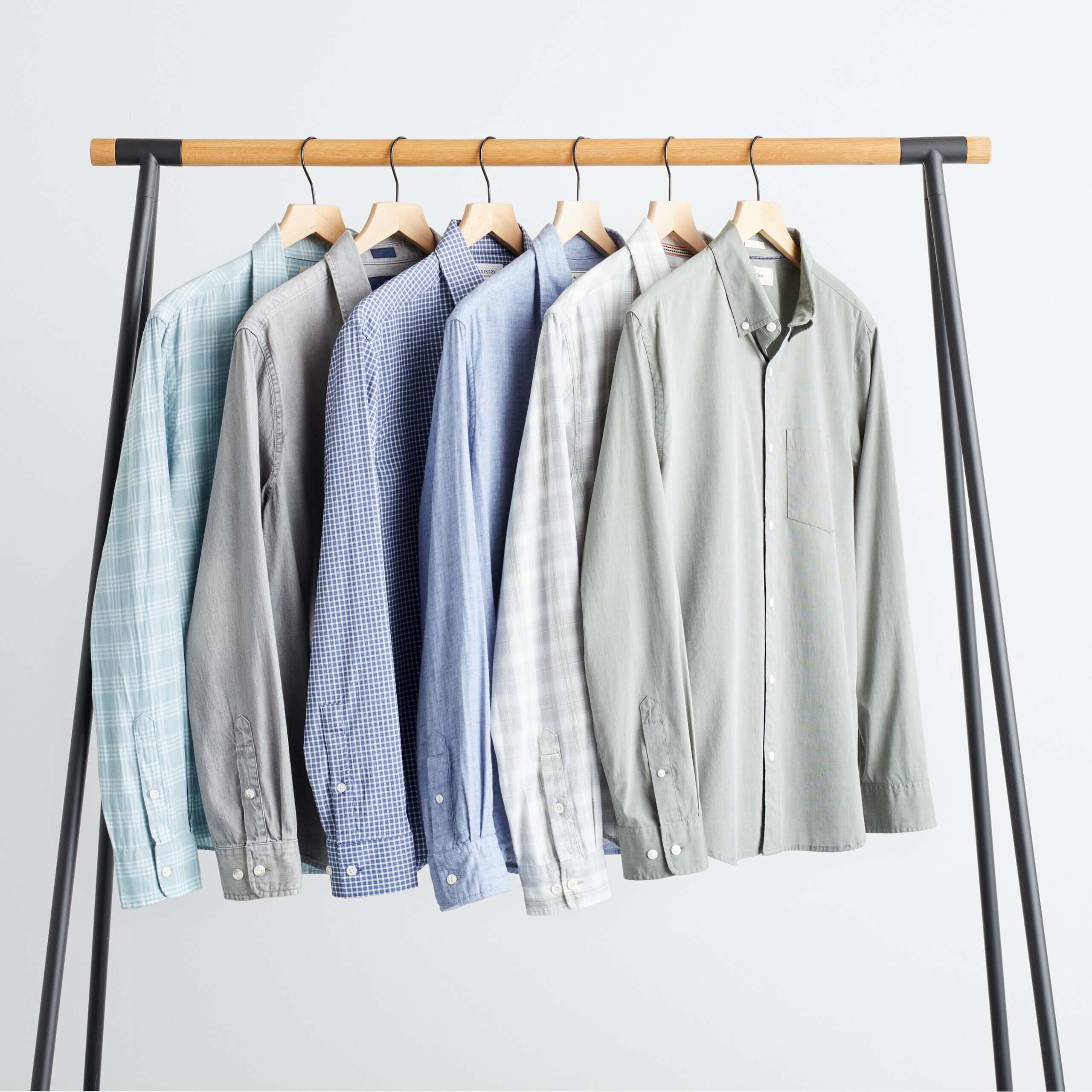 Stitch Fix men's collection of various button-down shirts hanging on rack.