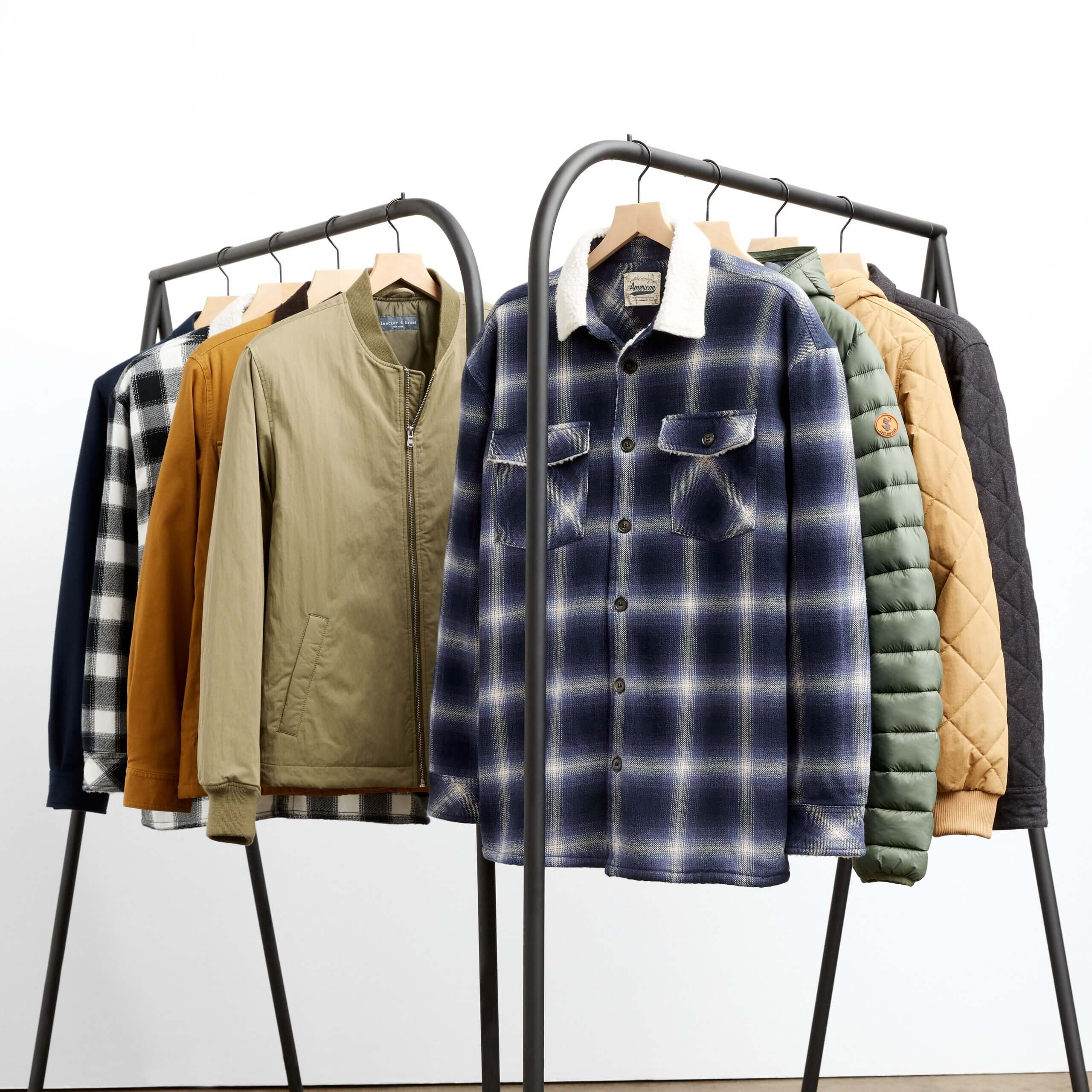 Stitch Fix men's collection of jackets hanging on rack including shackets, puffer jackets and bomber jackets.