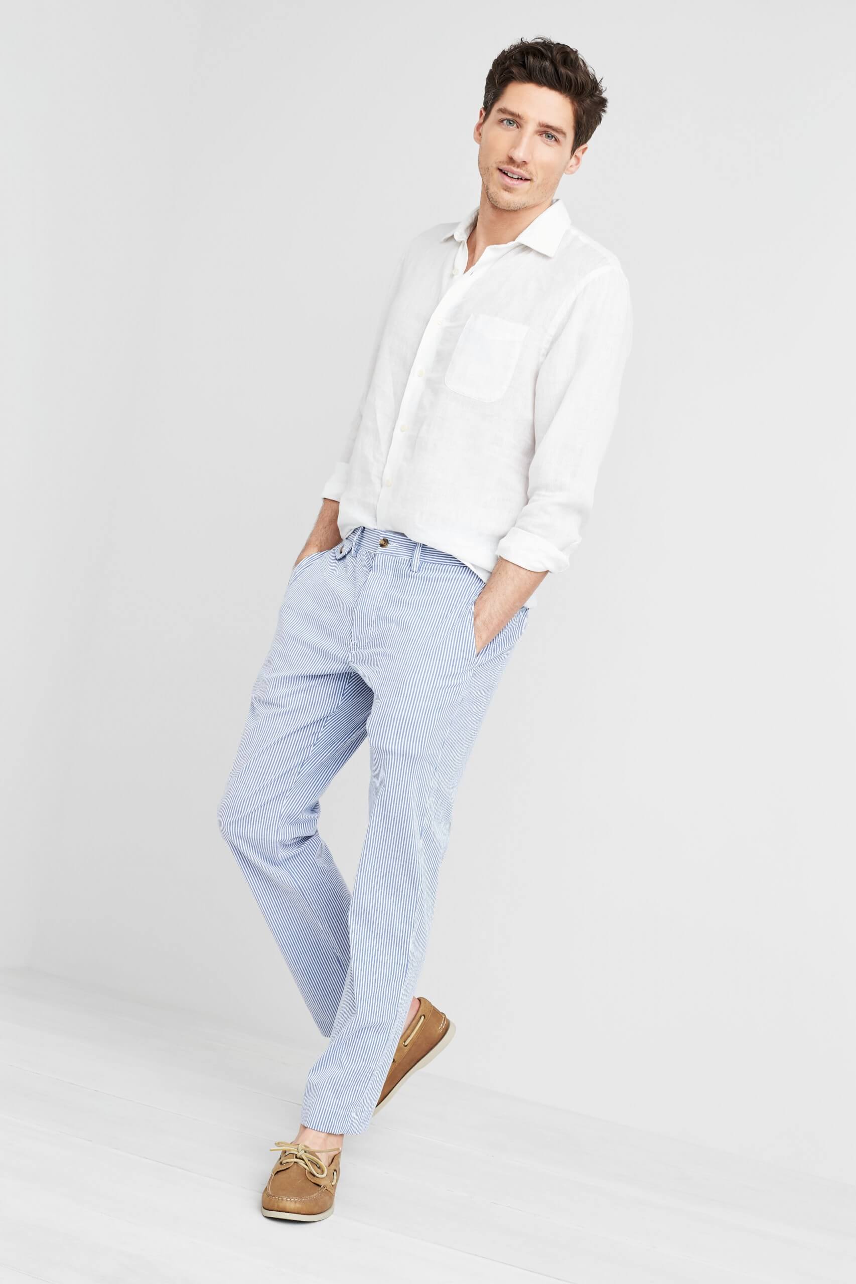 Stitch Fix Men's model wearing white button-down shirt, blue chinos and brown boat shoes.