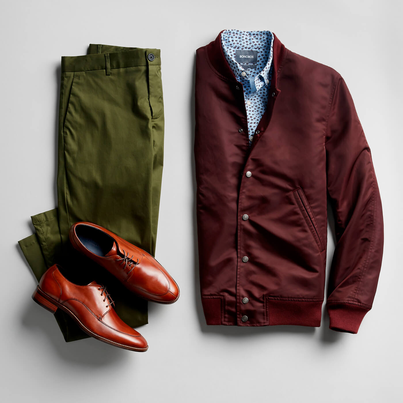 blue floral print shirt, maroon bomber jacket, cognac dress shoes and green chinos