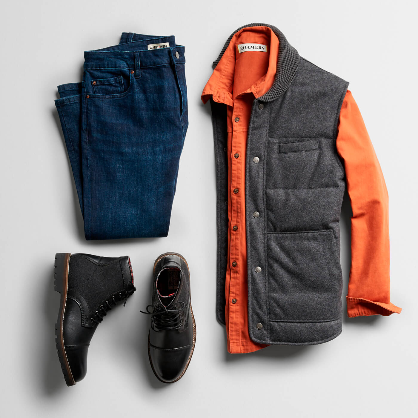 orange flannel shirt, grey vest, navy chinos and black chukka boots