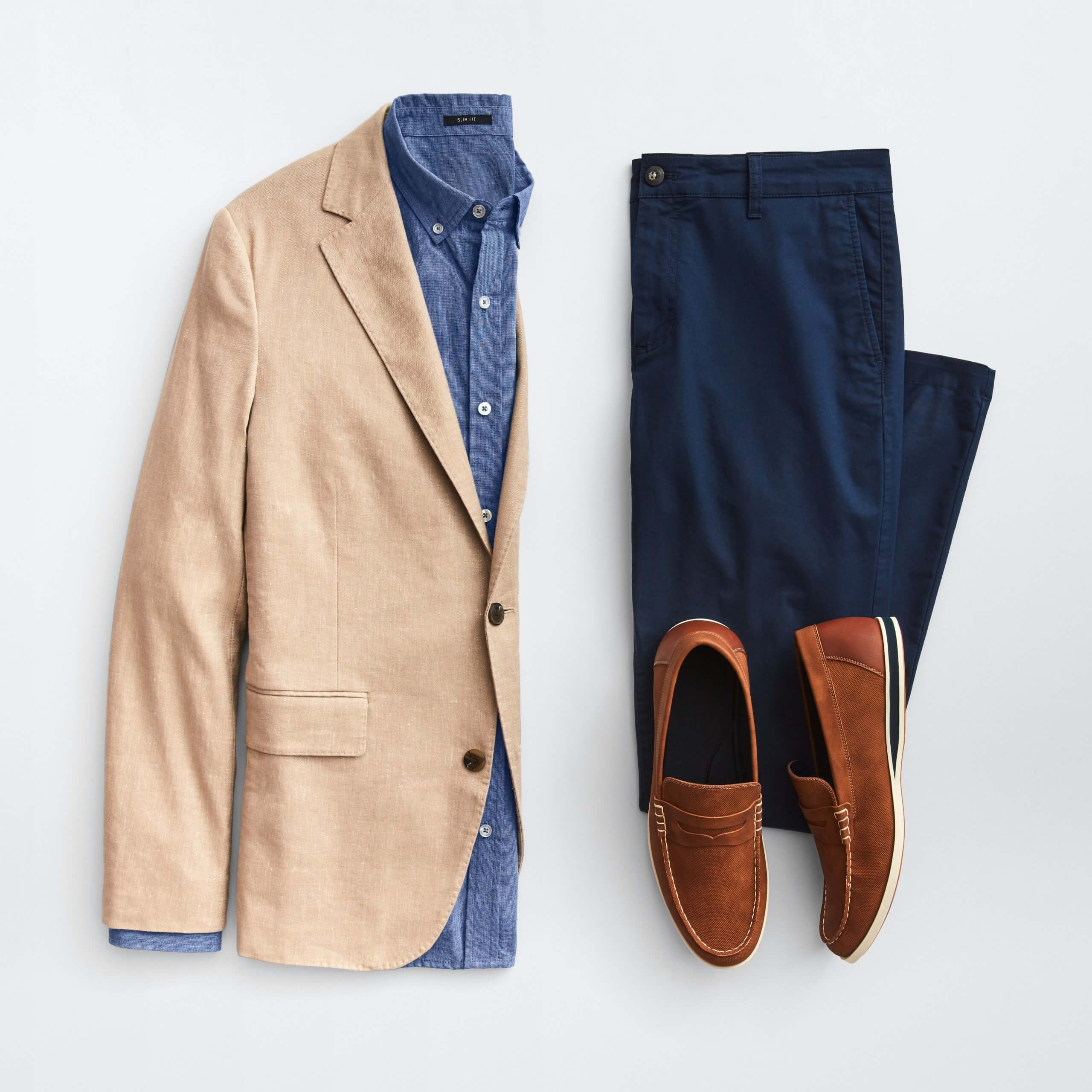 Stitch Fix Men’s outfit laydown featuring a tan blazer over a navy button-down shirt, next to navy pants and brown loafers.