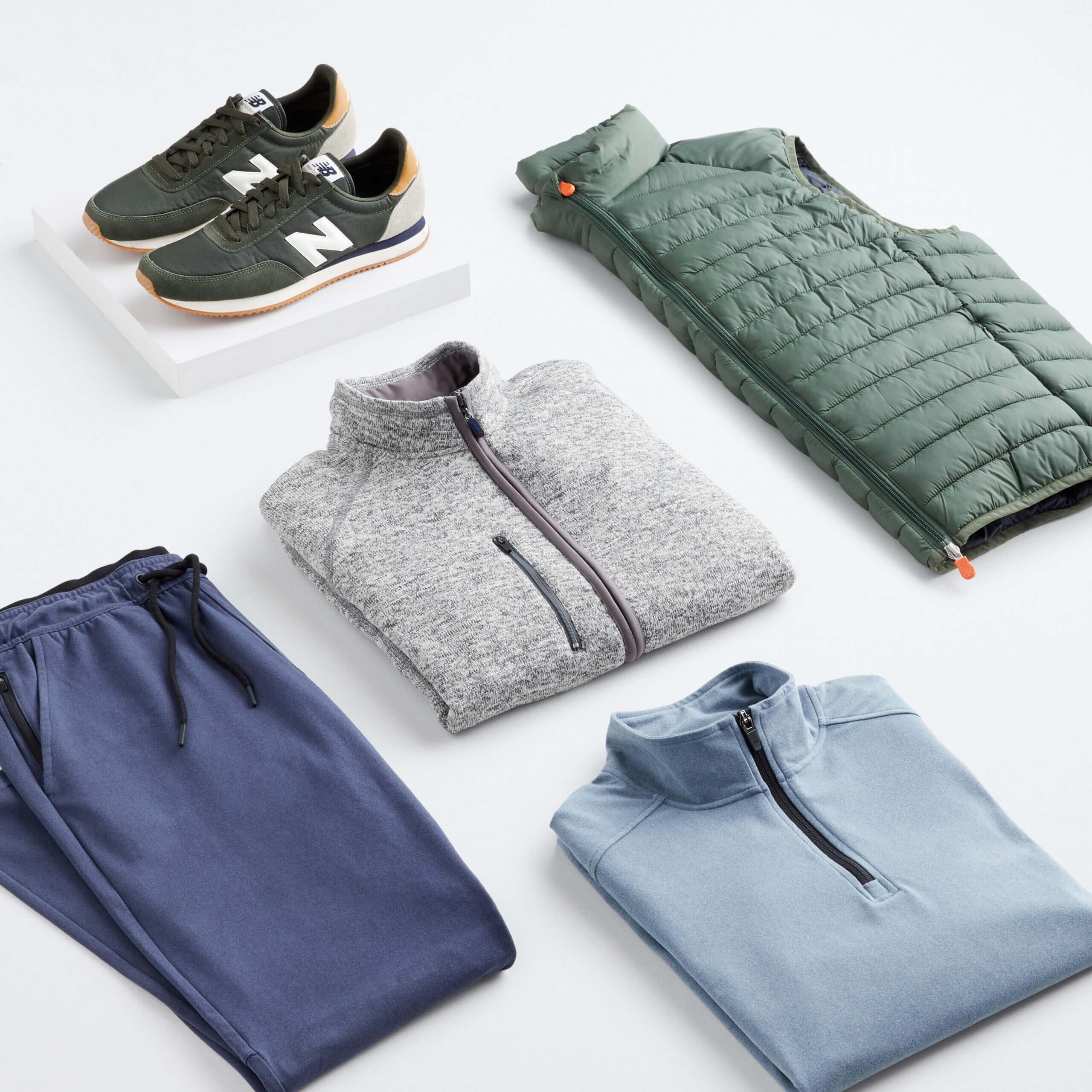Stitch Fix Men's Loungewear green puffer vest, grey and light blue quarter-zip, navy sweatpants, olive green sneakers.