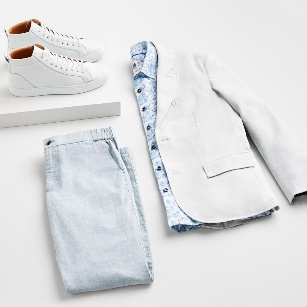 Stitch Fix Men’s Wedding outfit featuring light blue chinos, blue floral print button-down, grey blazer and white sneakers.
