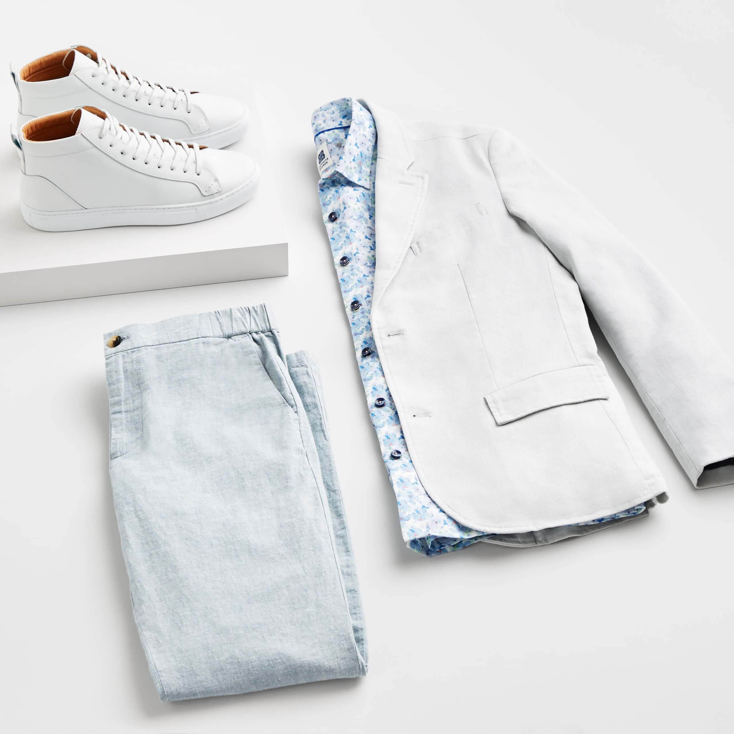 Stitch Fix Men’s Wedding outfit featuring light blue chinos, blue floral print button-down, grey blazer and white sneakers.