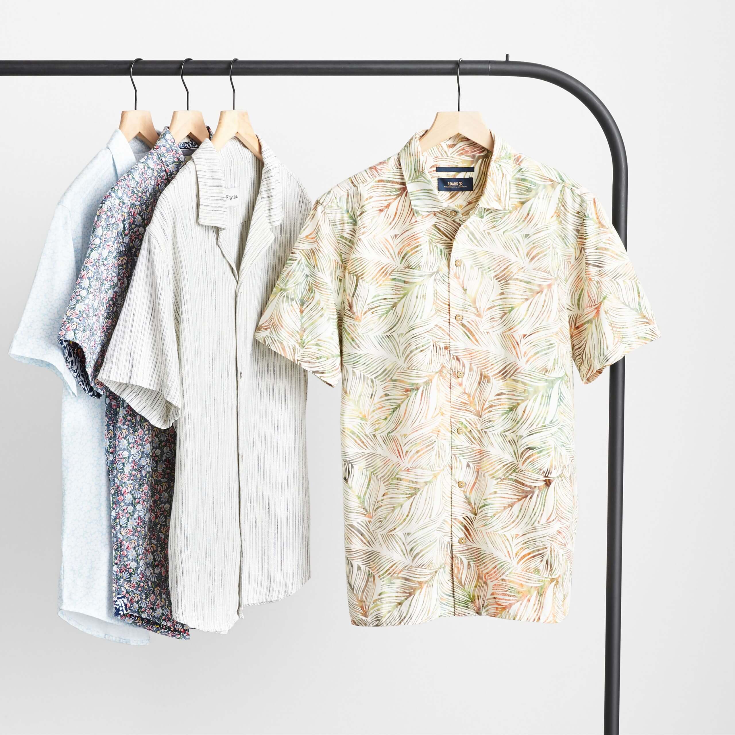 Stitch Fix Men’s four patterned short-sleeved button-downs hanging on a black rack. 