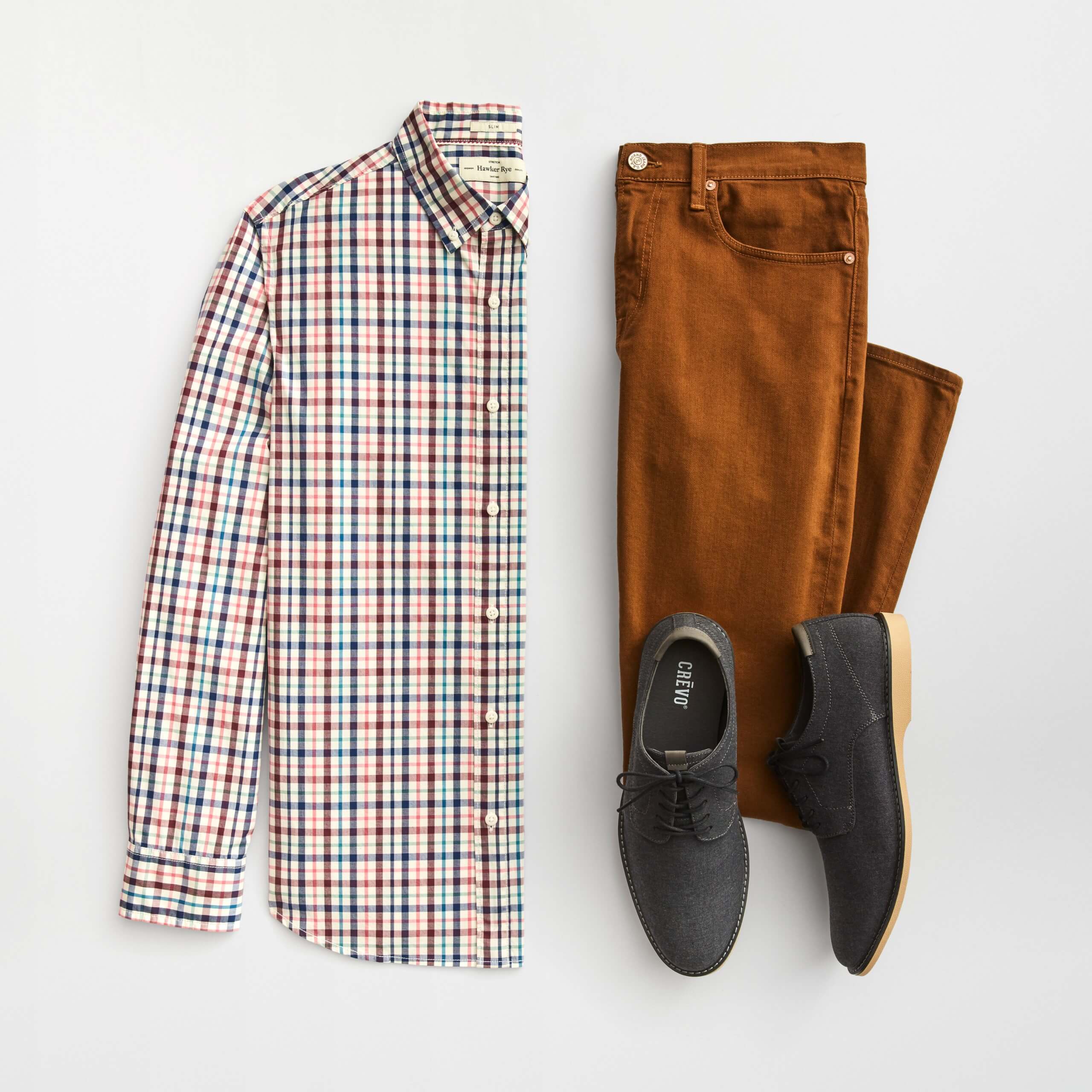 Stitch Fix Men’s outfit laydown featuring multi-colored button-up shirt, brown colored skinny jeans and grey oxford shoes.