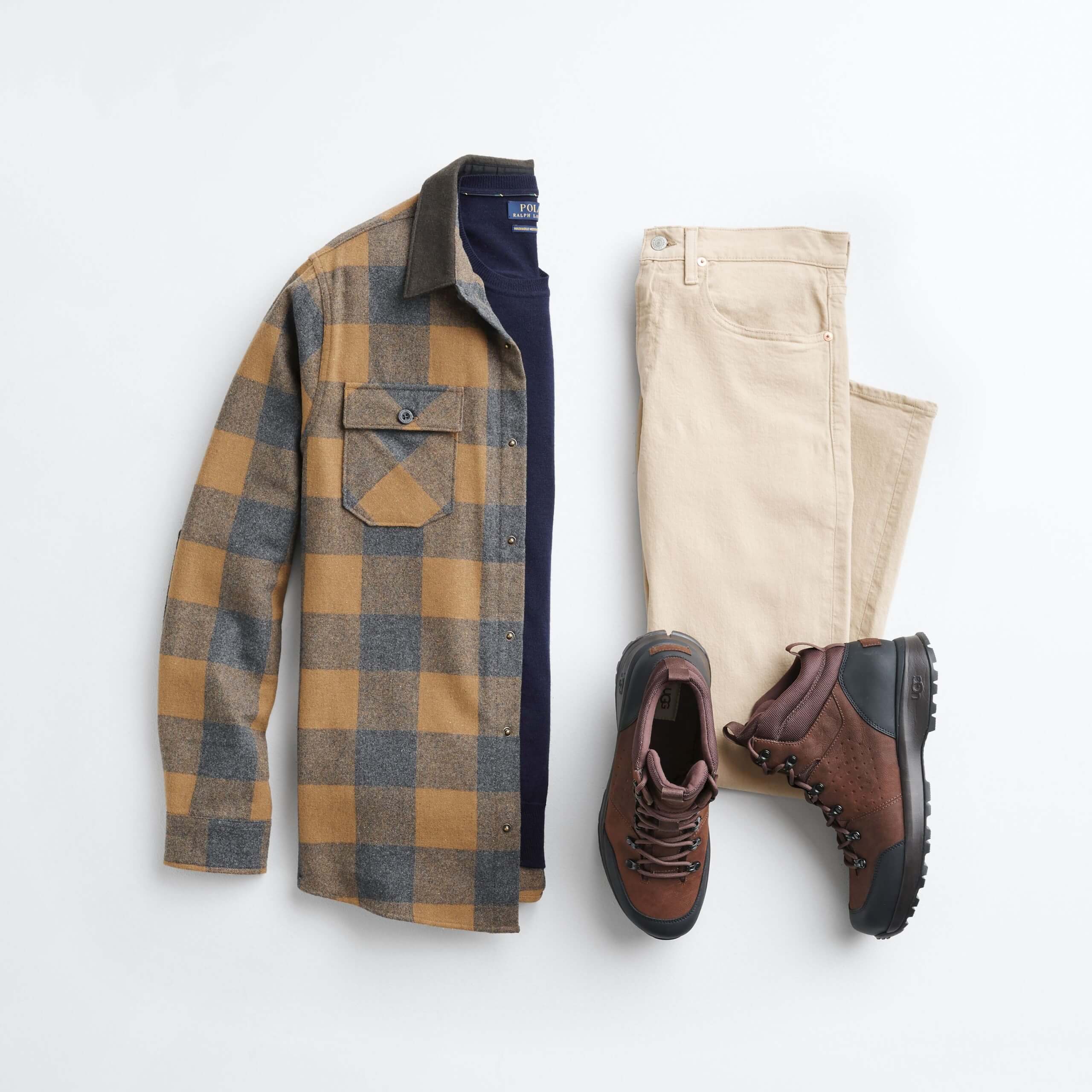 Stitch Fix Men’s outfit laydown featuring mustard flannel over navy crewneck sweater, khaki jeans and brown hiker boots. 