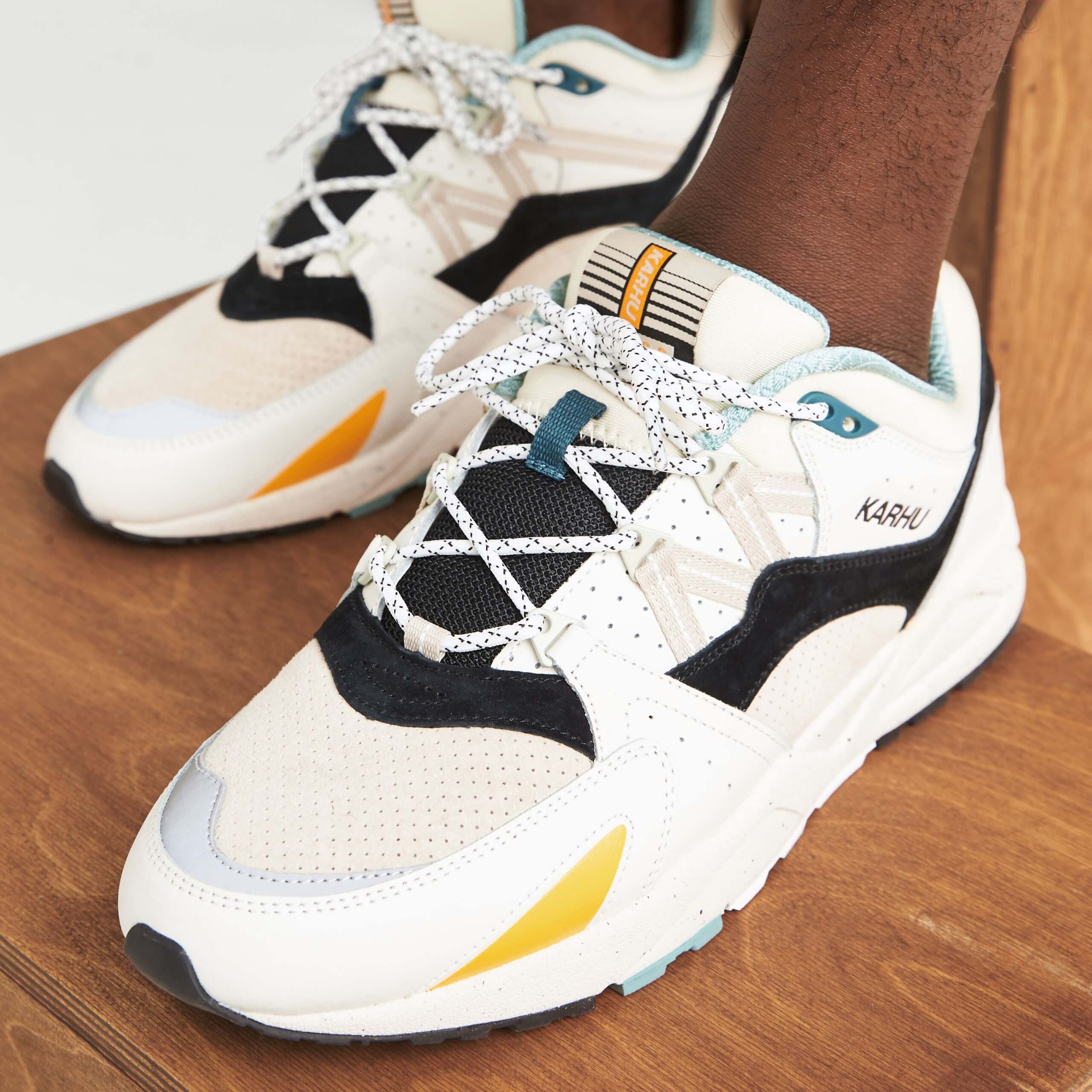 Stitch Fix men’s white lace-up sneakers with yellow, orange, blue and black accents.