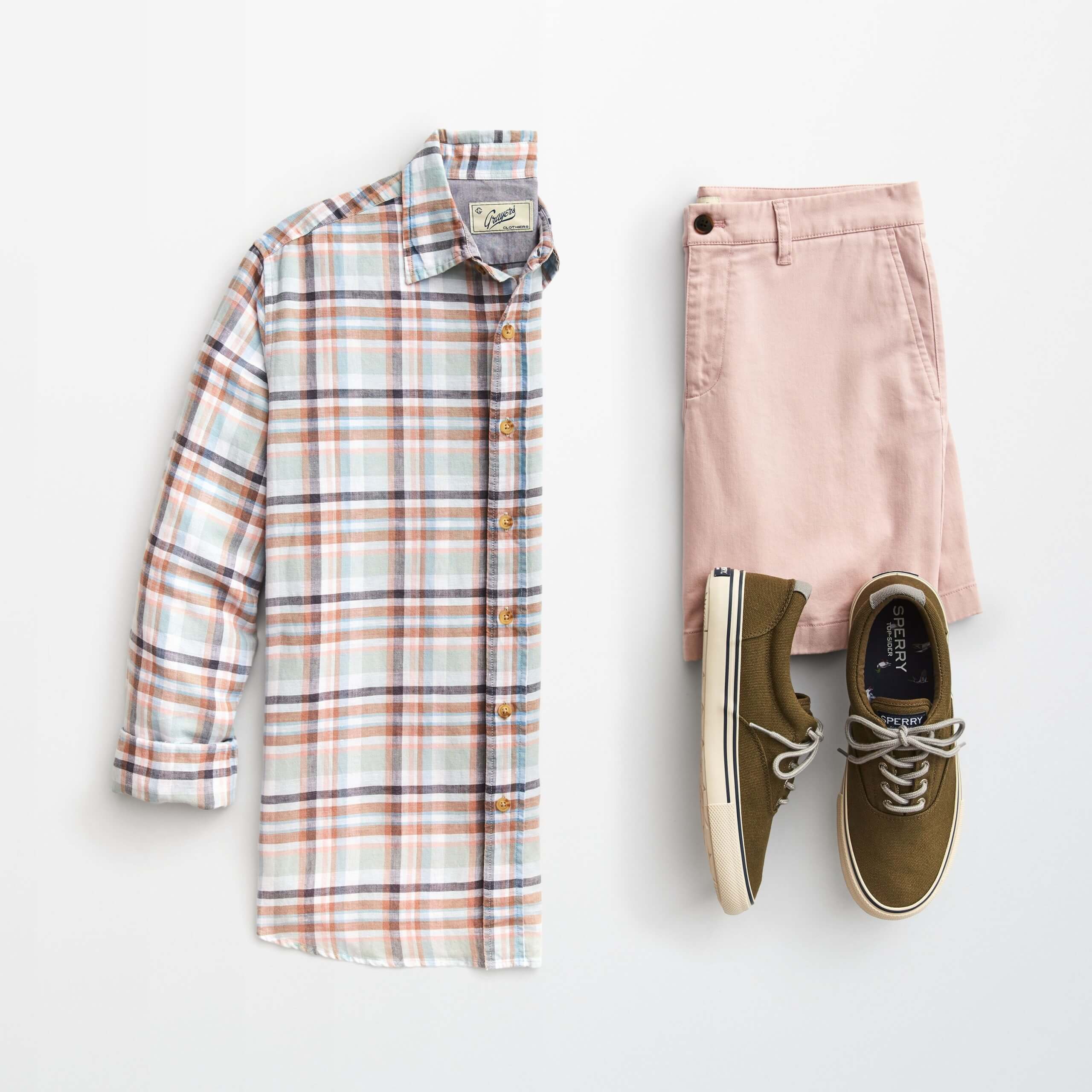 Stitch Fix men’s outfit laydown featuring plaid long-sleeve button-down, blush shorts and brown sneakers.