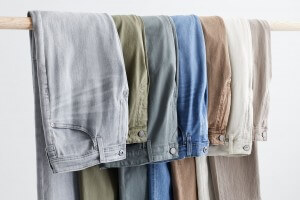 Stitch Fix Men’s assortment of grey, olive, blue, brown, off-white and taupe washes draped over a hanger.