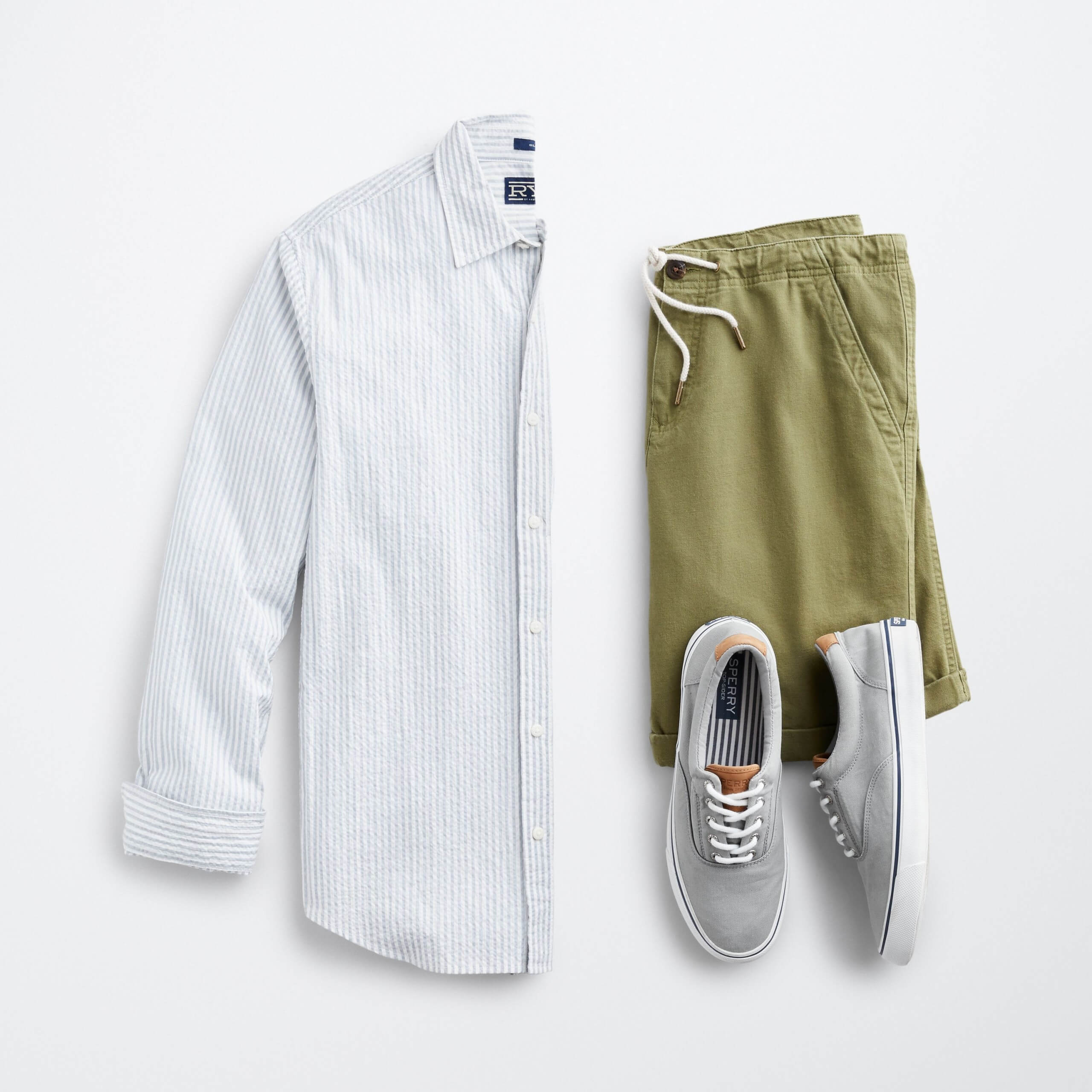 Stitch Fix Men’s outfit laydown featuring white and blue striped long-sleeve button-down, olive shorts and grey sneakers.