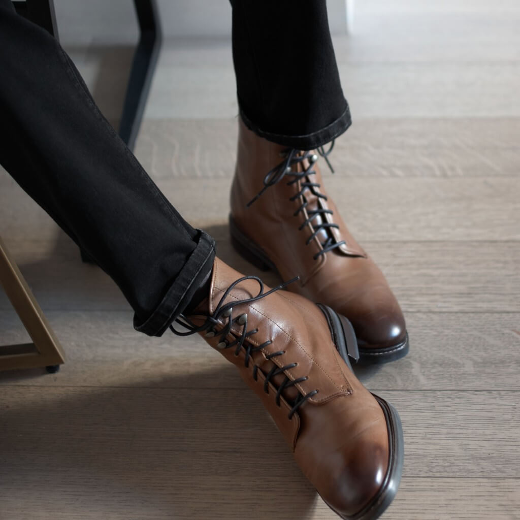 Stitch Fix men’s model wearing black skinny jeans and brown lace-up boots.