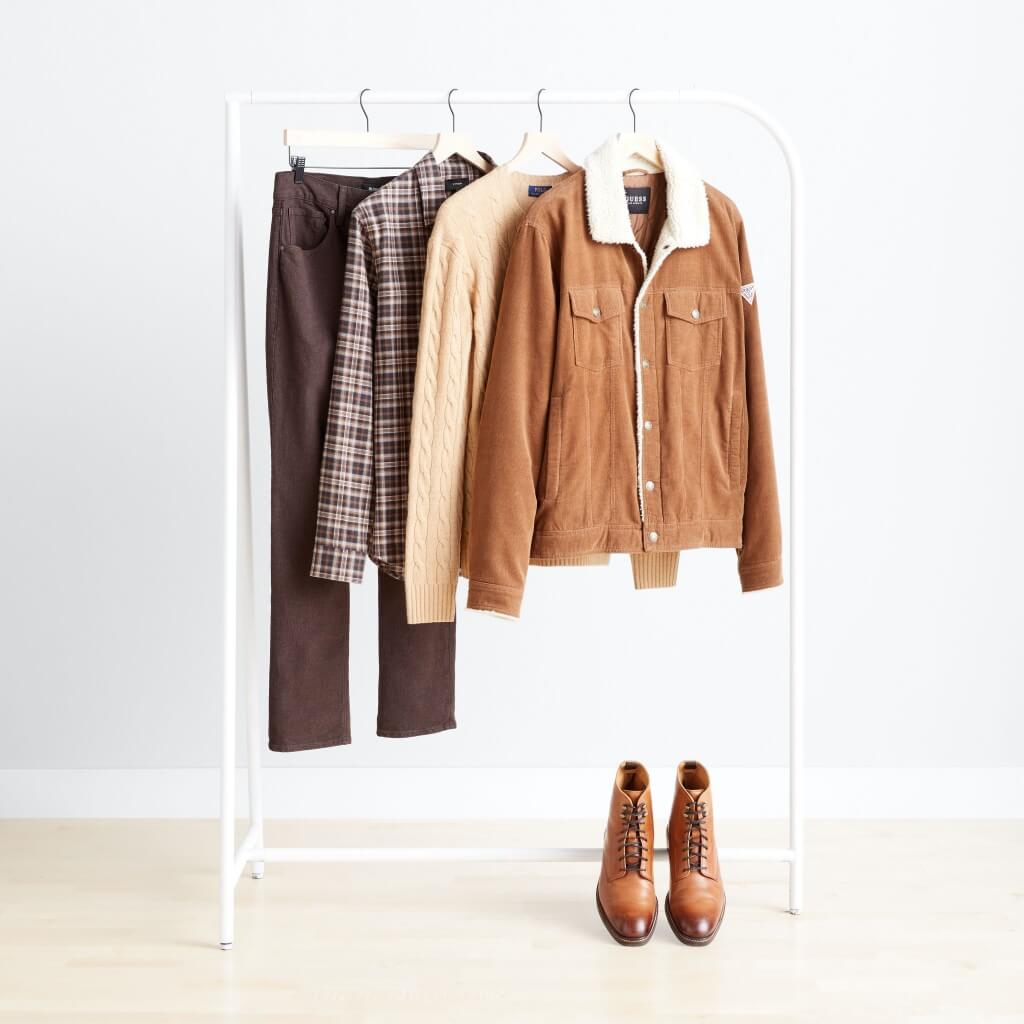 Stitch Fix men’s clothing hanging in a variety of brown colors and prints with brown lace-up boots.