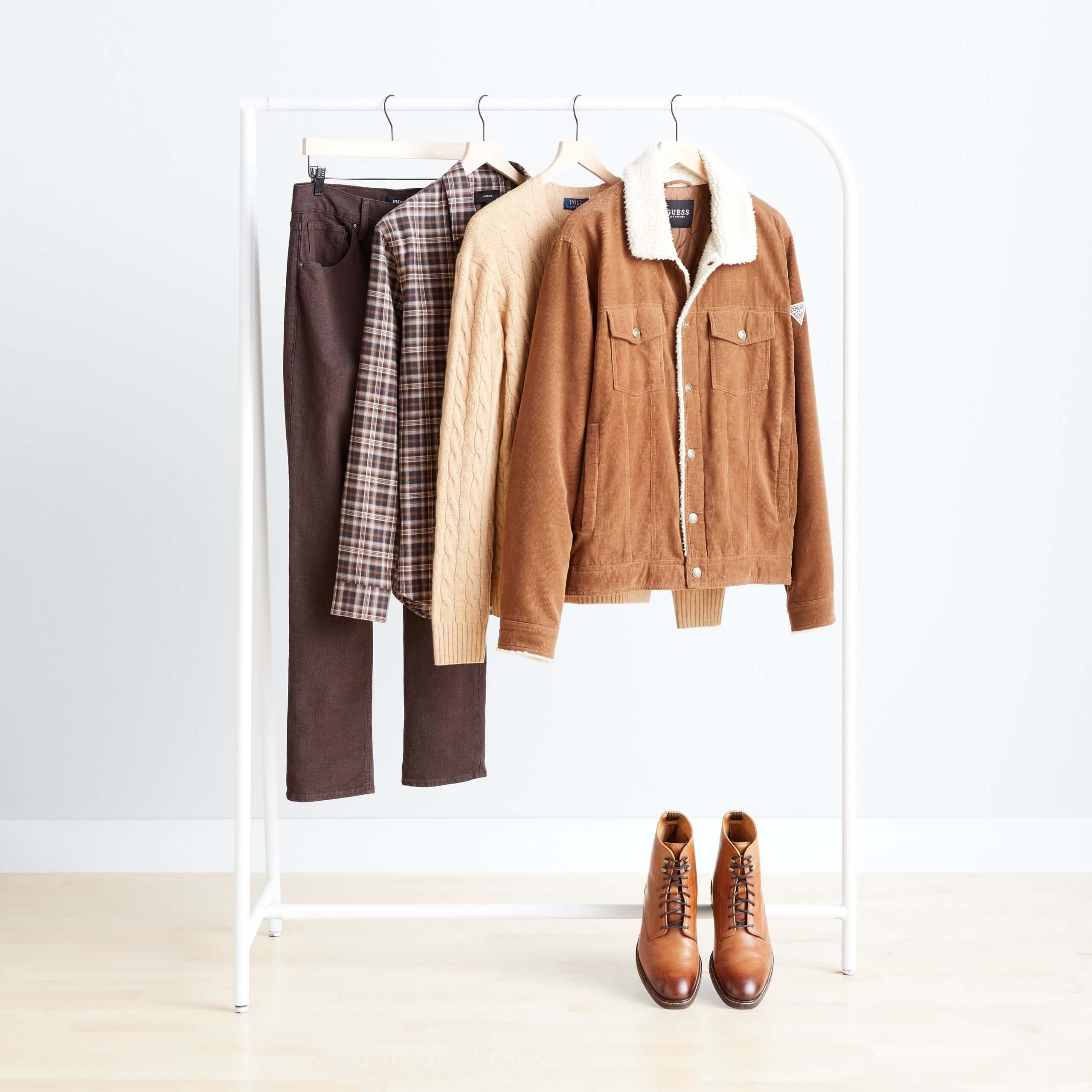 Stitch Fix men’s clothing hanging in a variety of brown colors and prints with brown lace-up boots.