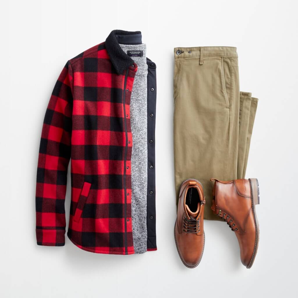 Stitch Fix men’s winter outfit with red and black buffalo check jacket over a grey sweater, khaki pants and brown boots.