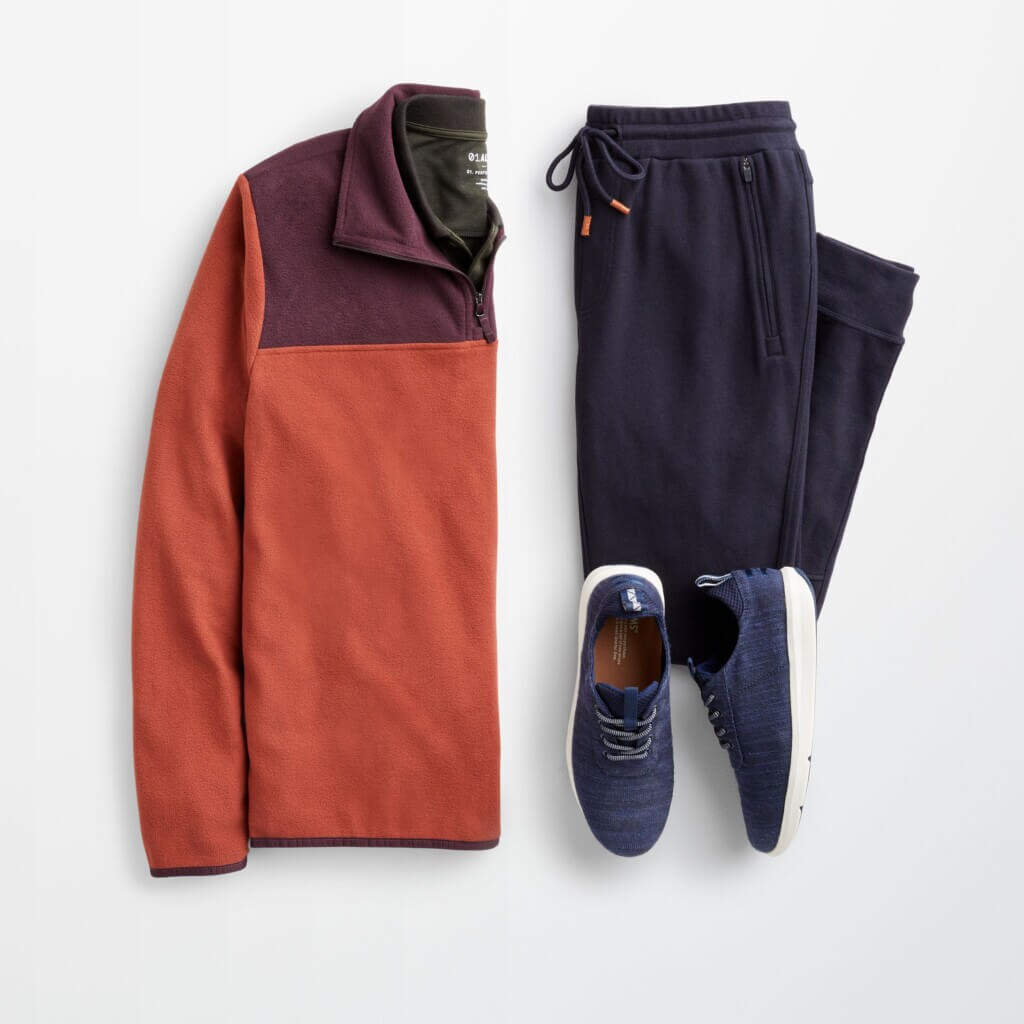 Stitch Fix men’s winter outfit featuring orange and burgundy quarter zip, navy joggers and blue sneakers.