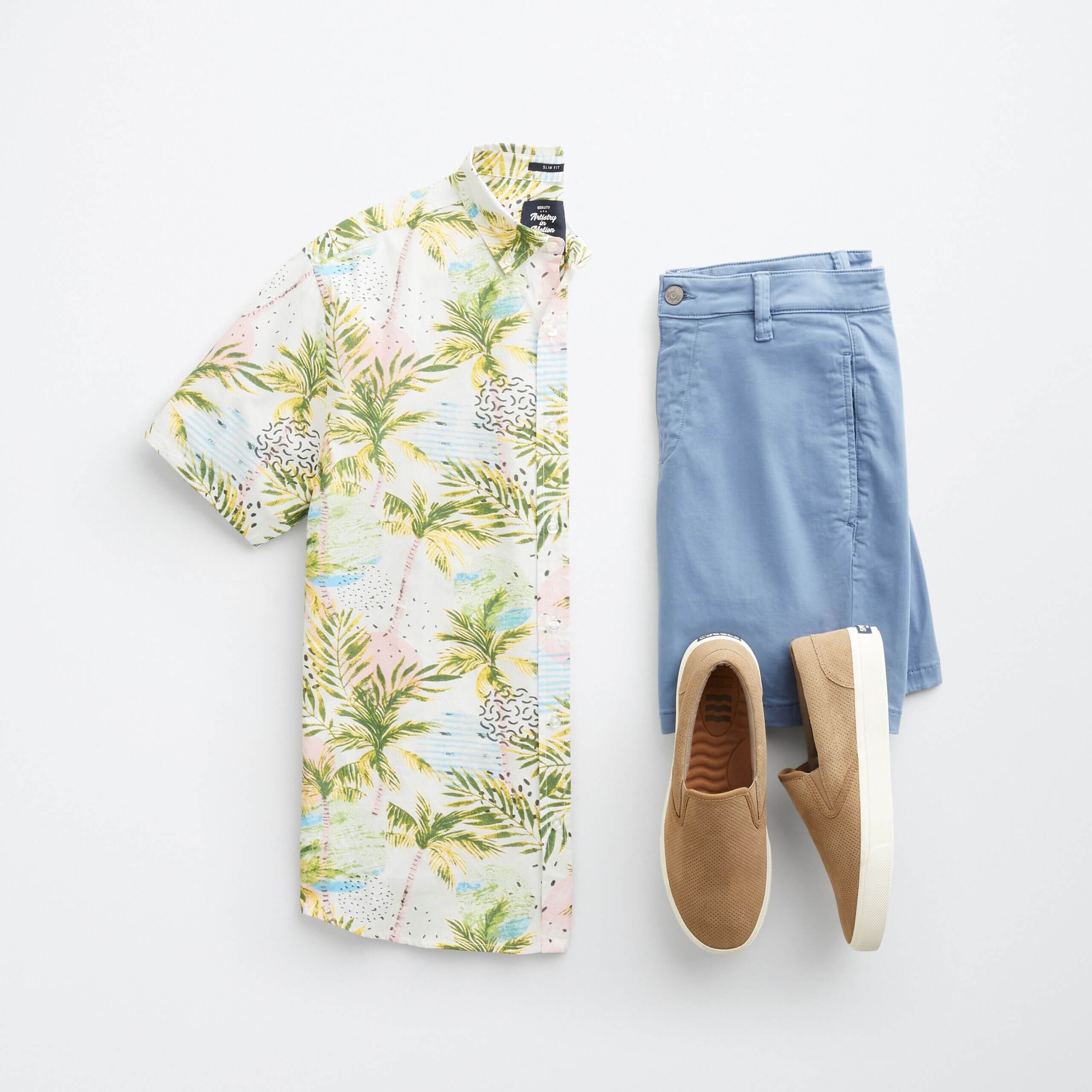 Stitch Fix men’s resort wear outfit with colorful palm-print short-sleeve shirt, blue shorts and tan slip-on sneakers.