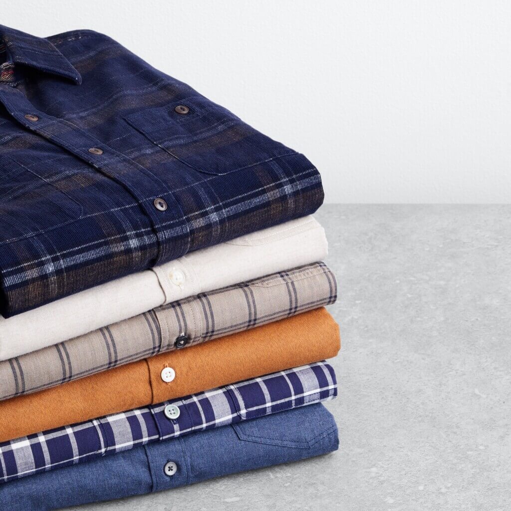 Stitch Fix men’s button-down shirts in various colors and patterns folded in a stack.