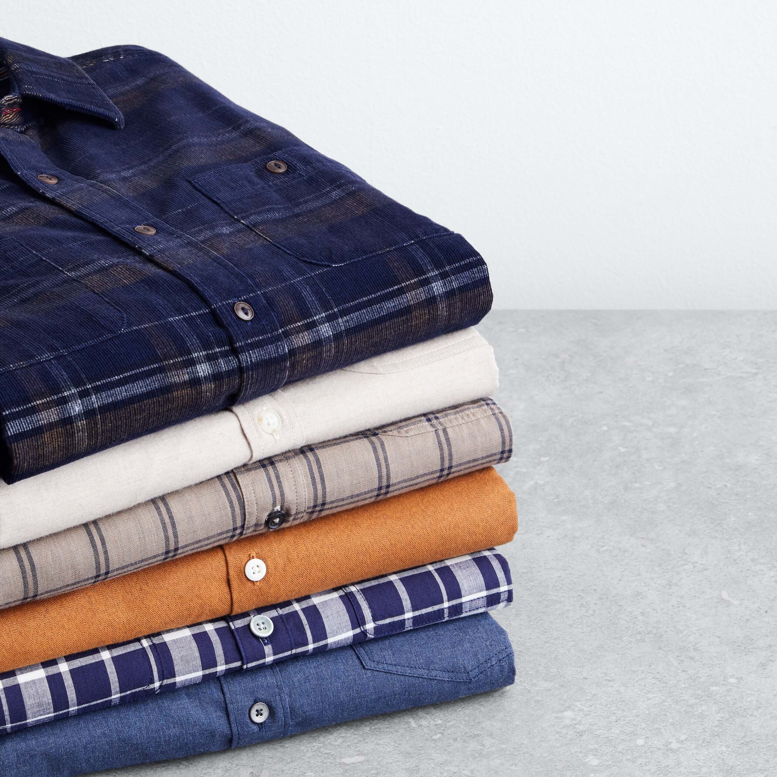 Stitch Fix men’s button-down shirts in various colors and patterns folded in a stack.