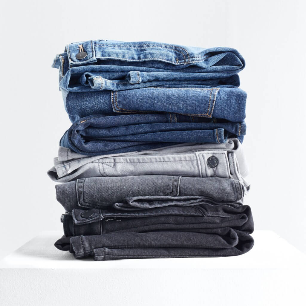 Stitch Fix men’s stack of light blue, blue, grey and black jeans.