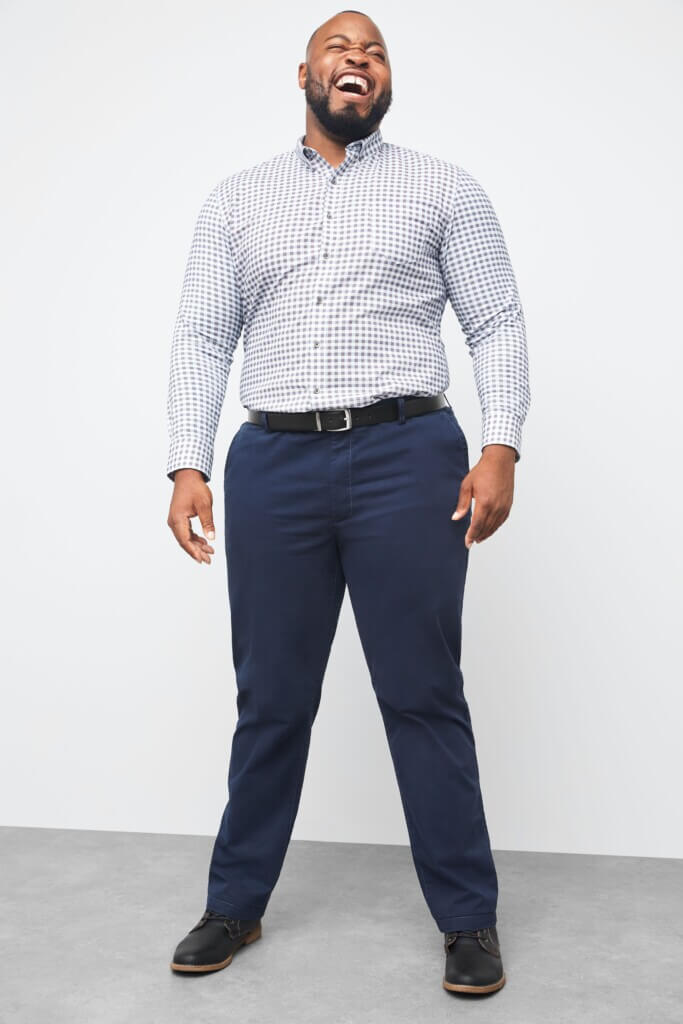 Stitch Fix model wearing men’s big and tall outfit with white and grey button-down shirt, navy pants, black belt and shoes.