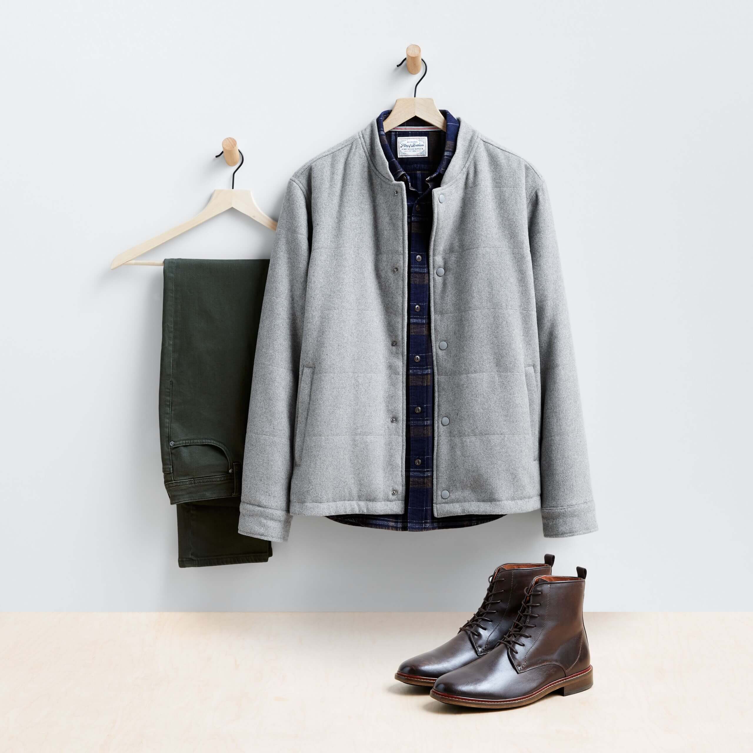 Stitch Fix Men’s Valentine's Day outfit featuring black pants on hanger next to black shirt with gray shacket on hanger and brown boots.