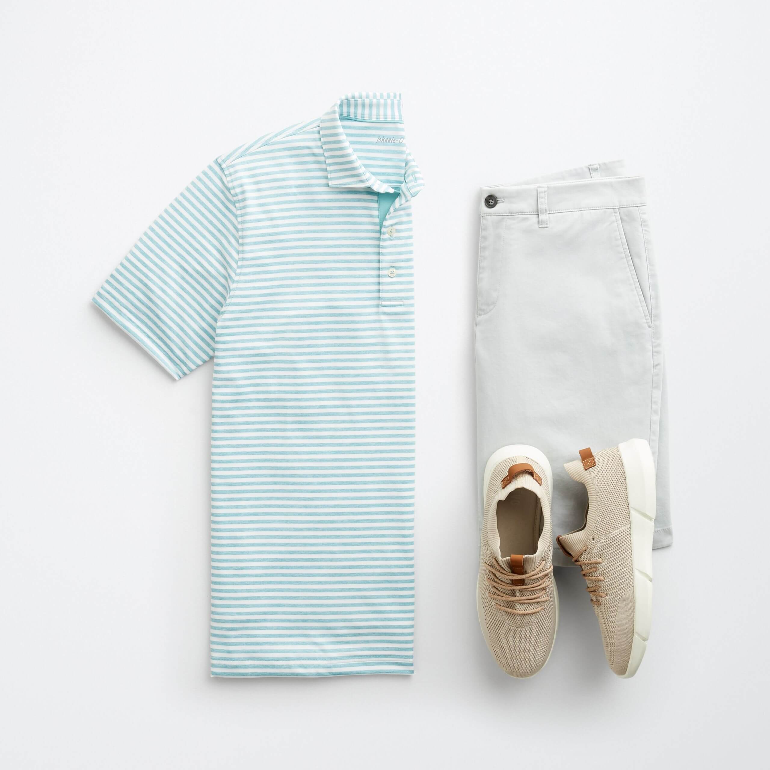 Stitch Fix men’s golf attire featuring a green striped polo, off-white pants and tan sneakers.