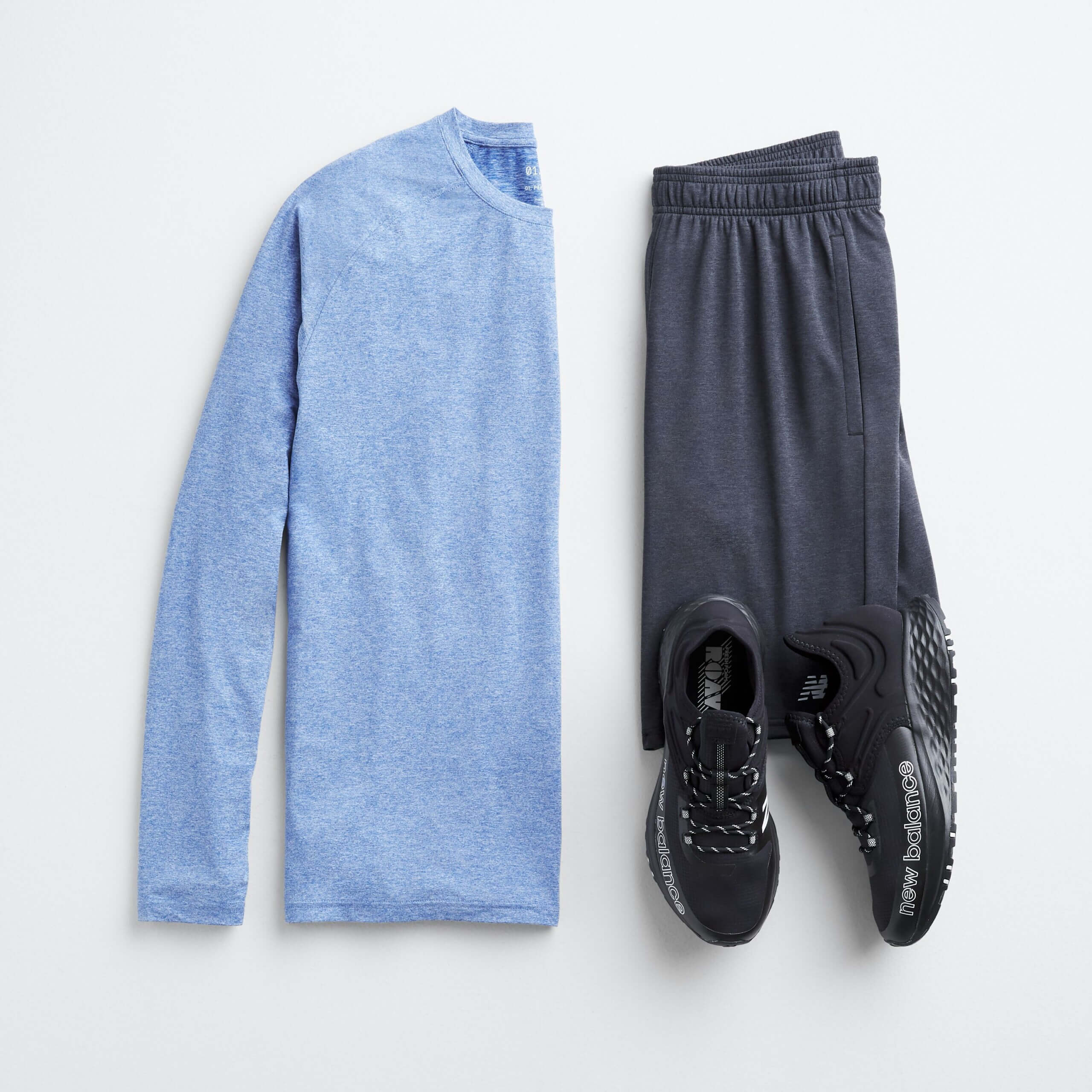 Stitch Fix men’s beach wear outfit featuring blue long-sleeve T-shirt, grey performance shorts and black sneakers.