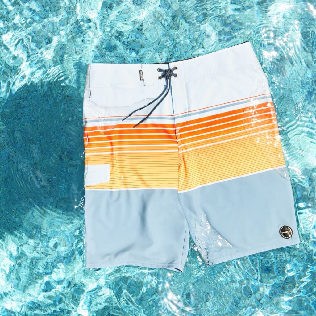 Stitch Fix men’s multi-colored board shorts floating on water.