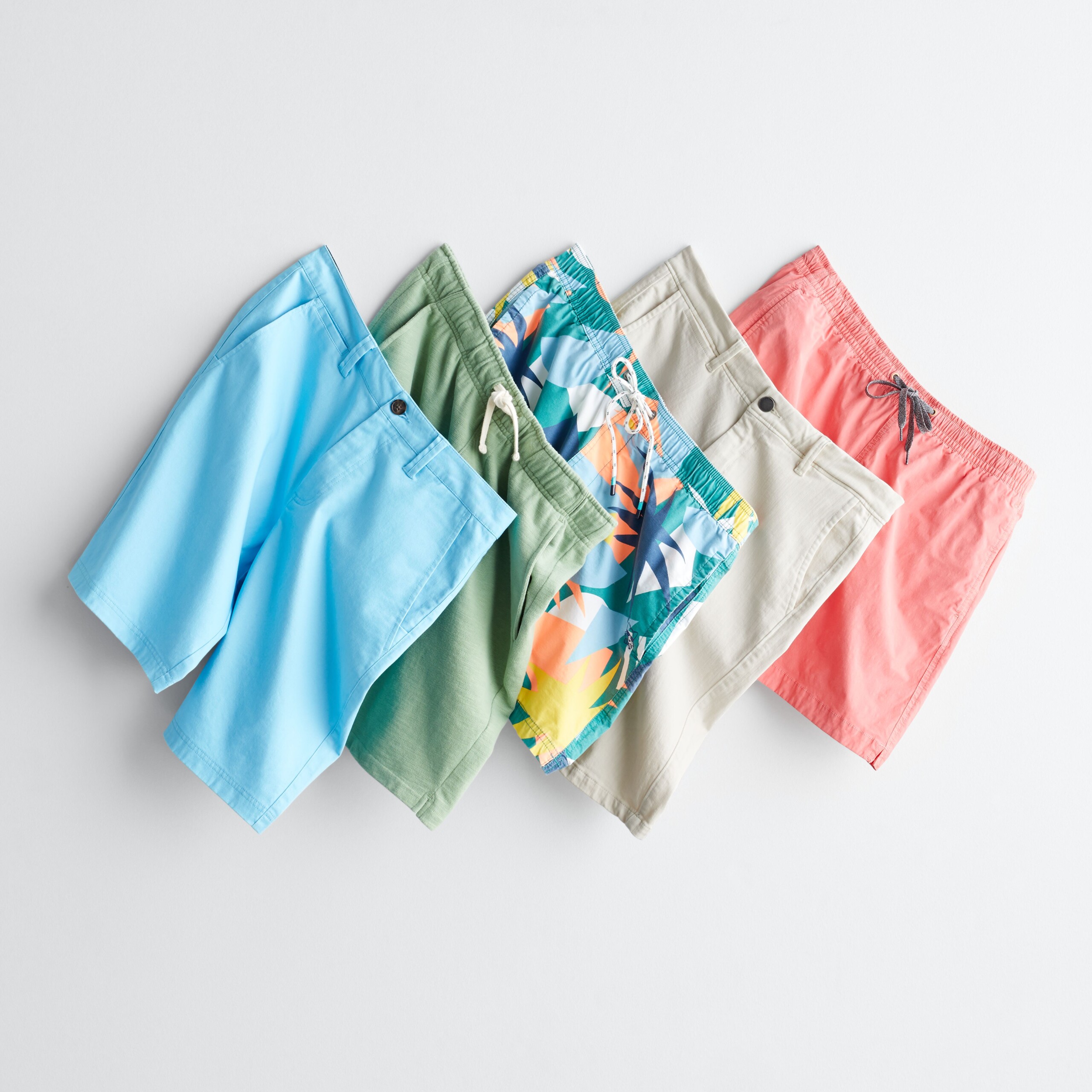 Stitch Fix men’s shorts in blue, green, khaki, orange and tropical print hanging on hooks.