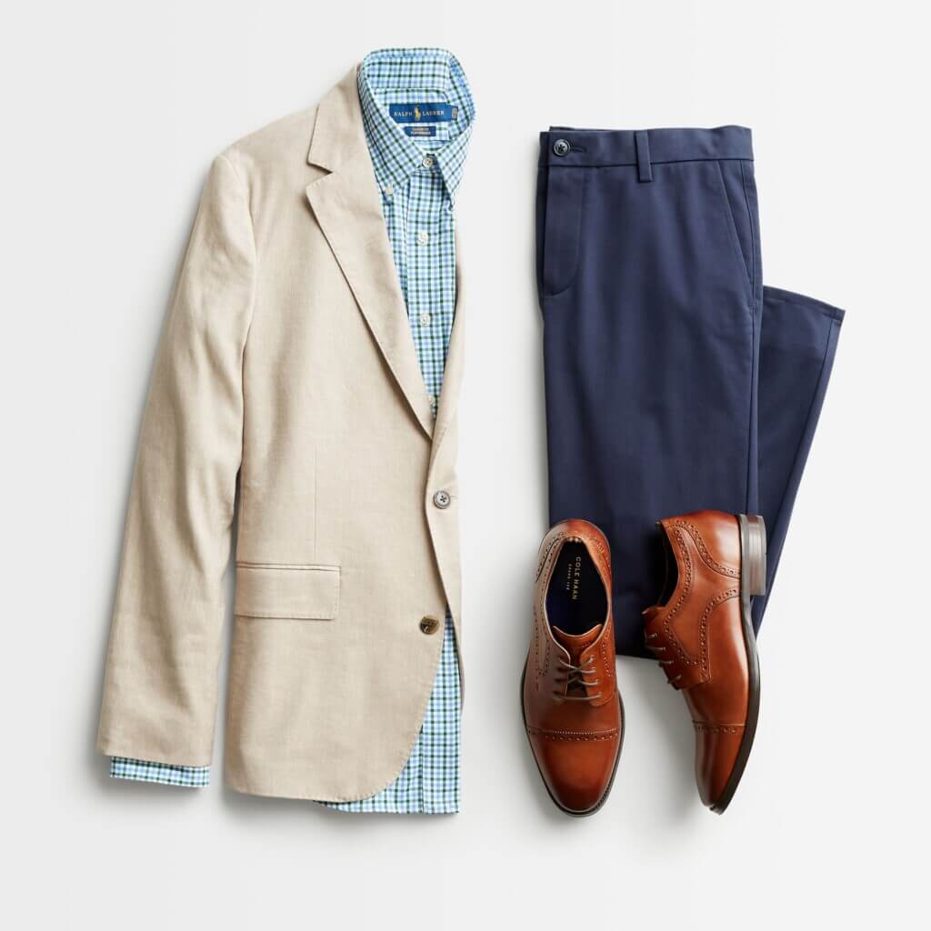 Stitch Fix men’s semi-formal wedding attire outfit with navy trousers, tan sport coat, blue plaid shirt and brown oxfords.