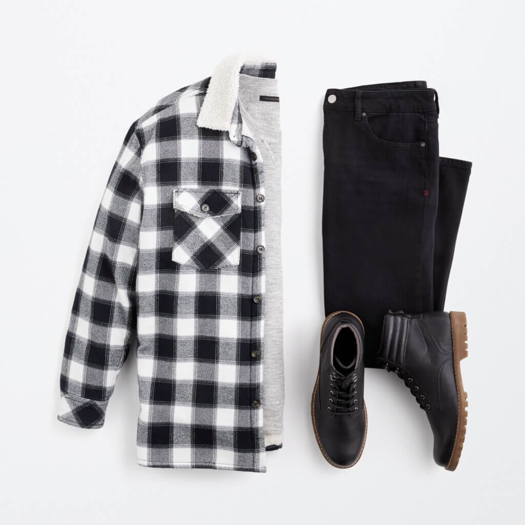 Stitch Fix men’s Y2K outfit for men with black jeans, grey sweater, black and white flannel jacket, and black utility boots.