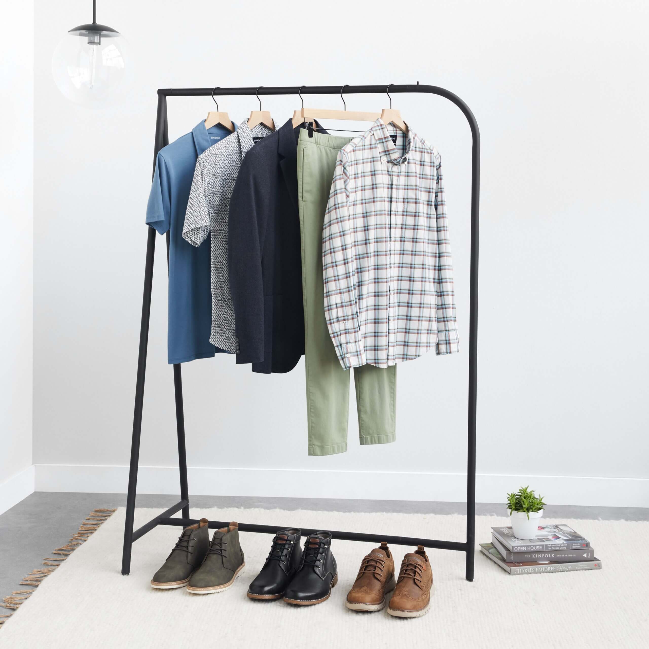 Stitch Fix men’s wedding attire outfit with shirts, pants and jackets hanging on rack next to various dress shoes and decor.