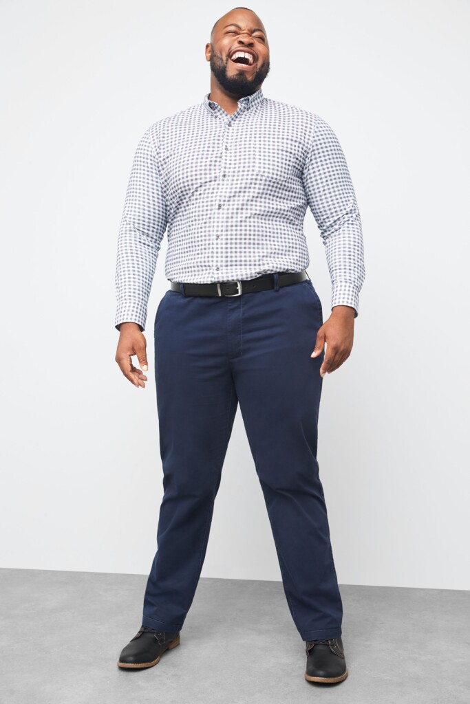 Stitch Fix model wearing men's business casual attire with navy trousers, blue and white button-down, black shoes and belt.