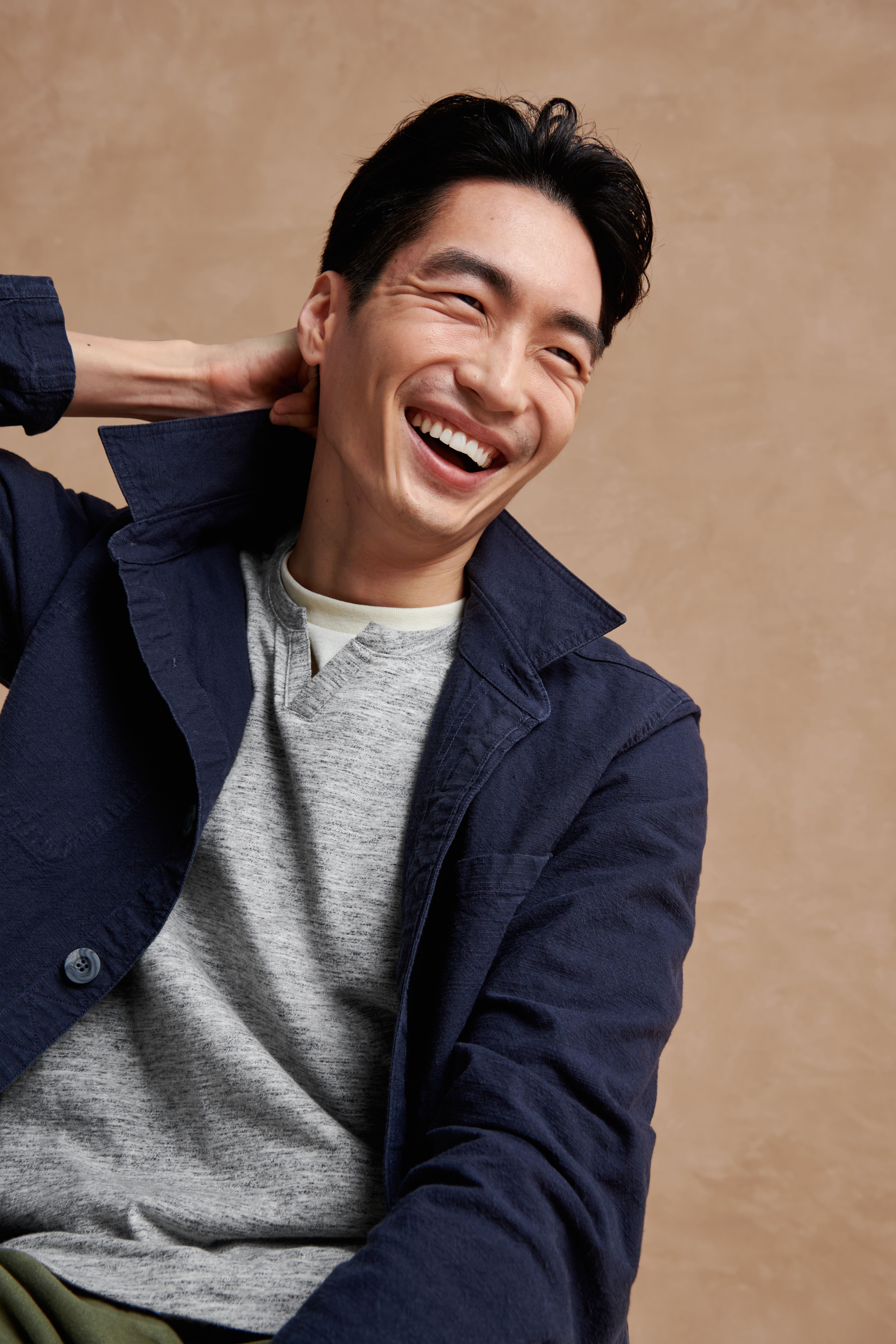 Stitch Fix model wearing men's business casual attire with grey knit shirt, white T-shirt and navy blue shirt-jacket.