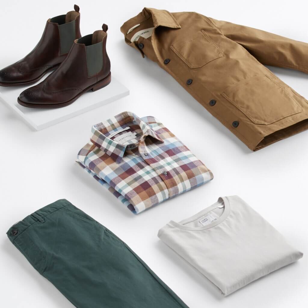 Stitch Fix men's business casual outfit featuring teal chinos, grey tee, plaid shirt, tan jacket and brown chelsea boots.