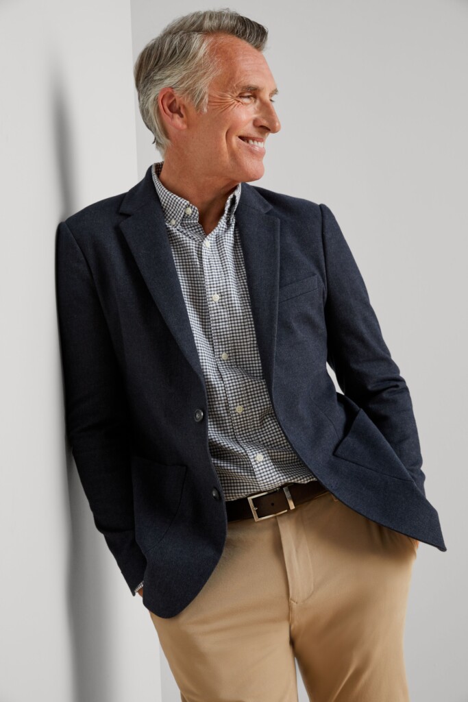 Stitch Fix model wearing men's business casual attire with plaid button-down shirt, khaki pants, navy blazer and brown belt.